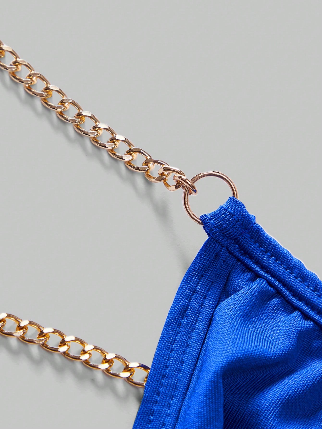 Men's low-rise thong underwear with metal chain detail, colorblock design, and high-stretch knitted fabric in a V-string style.
