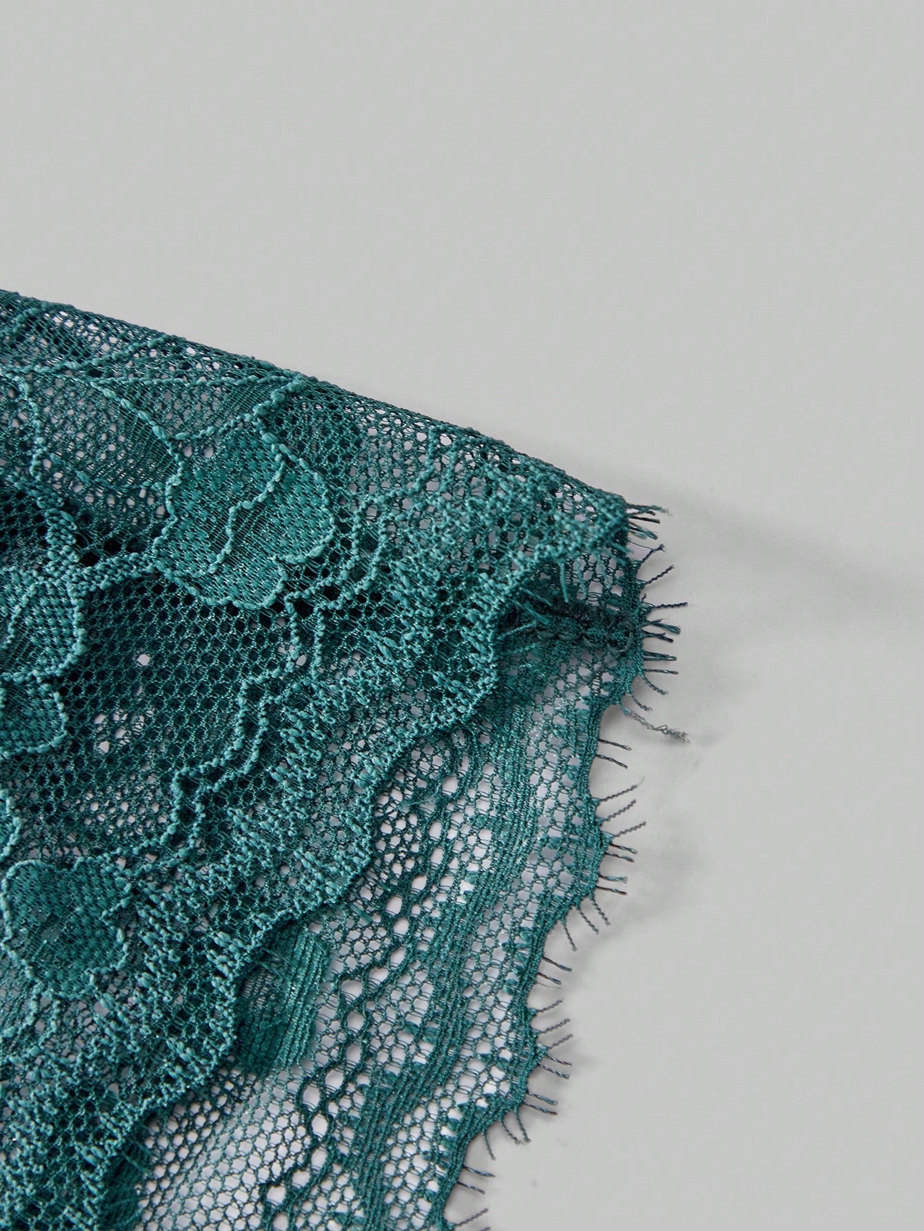 Dark green men's lace thong underwear with semi-sheer contrast lace, low-rise fit, and knitted stretch fabric.