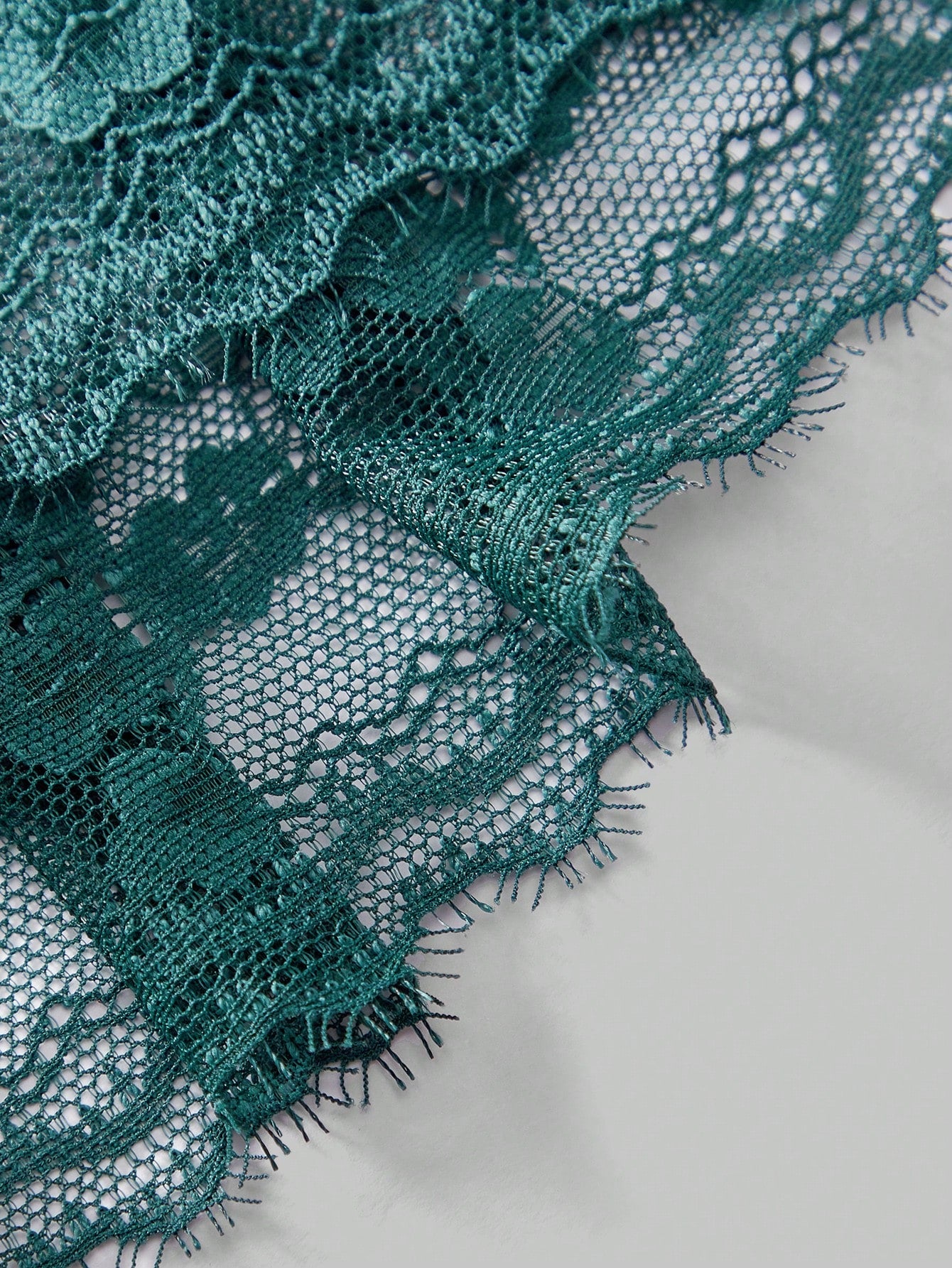 Dark green men's lace thong underwear with semi-sheer contrast lace, low-rise fit, and knitted stretch fabric.