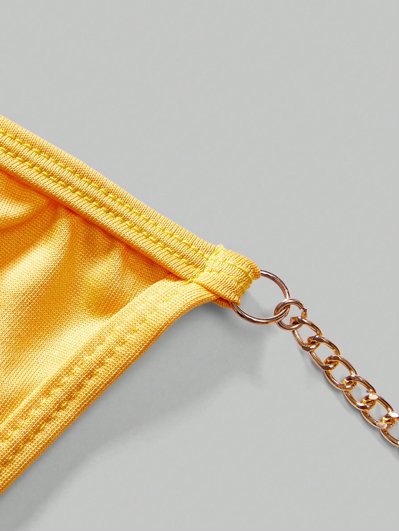 Men's low-rise thong underwear with metal chain detail, colorblock design, and high-stretch knitted fabric in a V-string style.