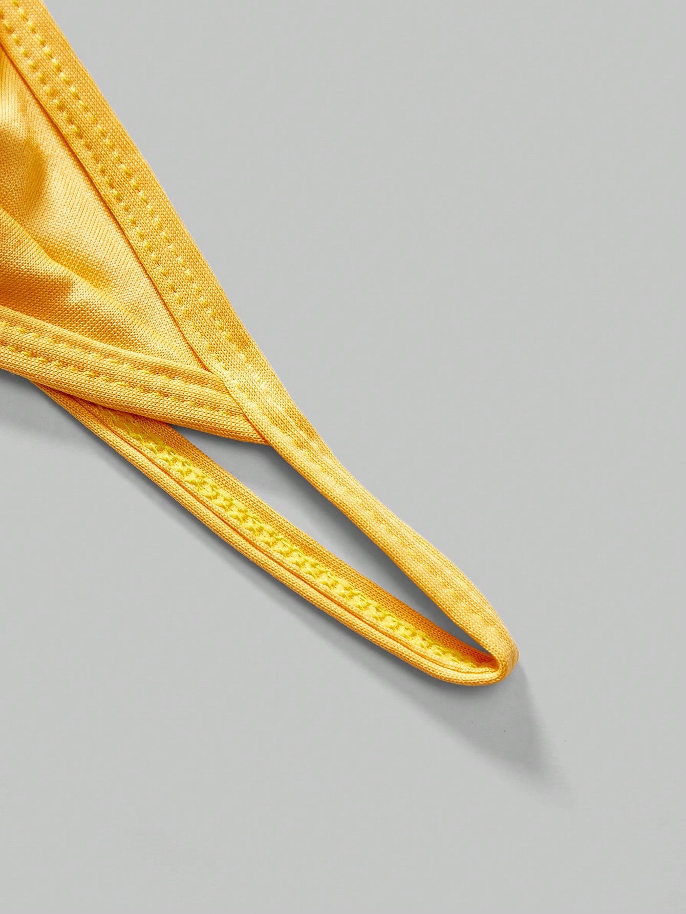 Men's low-rise thong underwear with metal chain detail, colorblock design, and high-stretch knitted fabric in a V-string style.