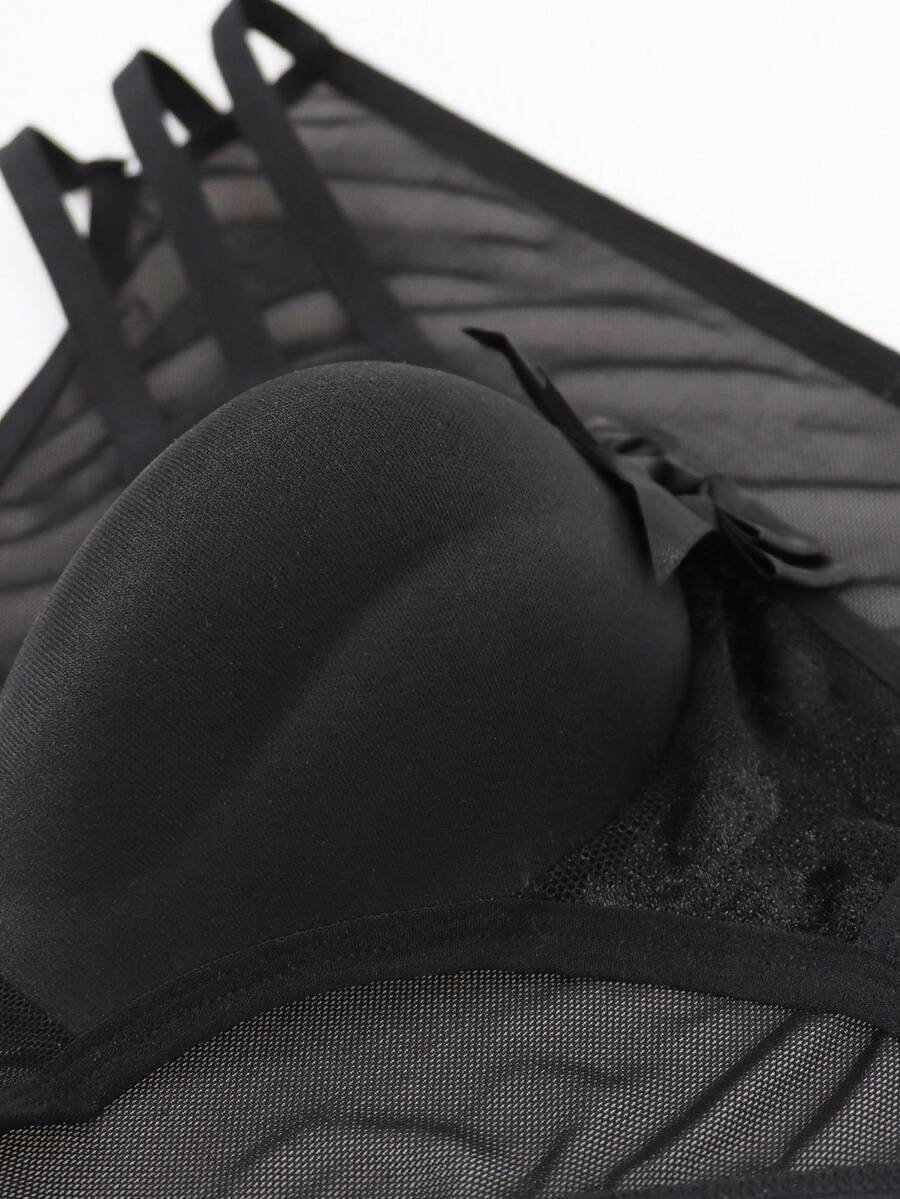 Men's black low-rise hollow mesh briefs featuring a zipper detail and striped pattern.