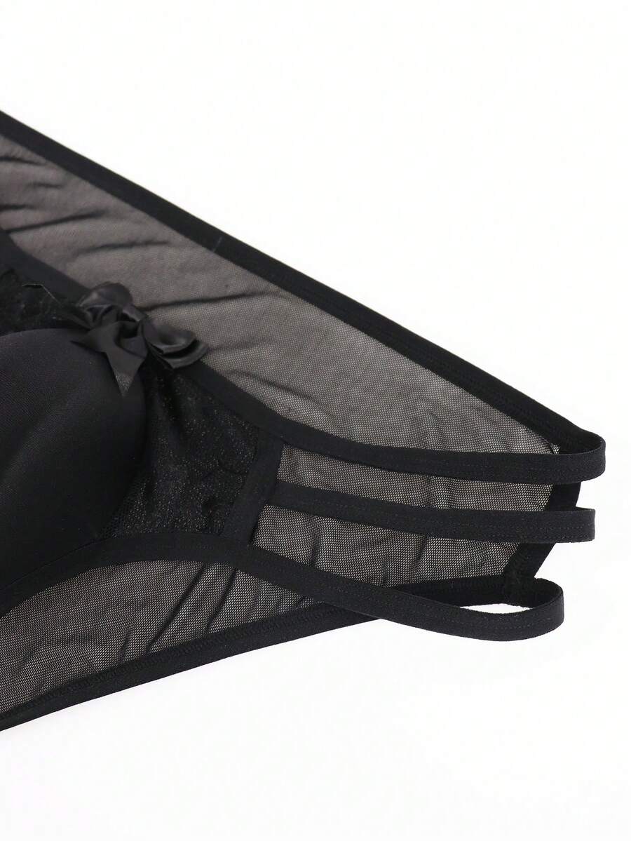 Men's black low-rise hollow mesh briefs featuring a zipper detail and striped pattern.