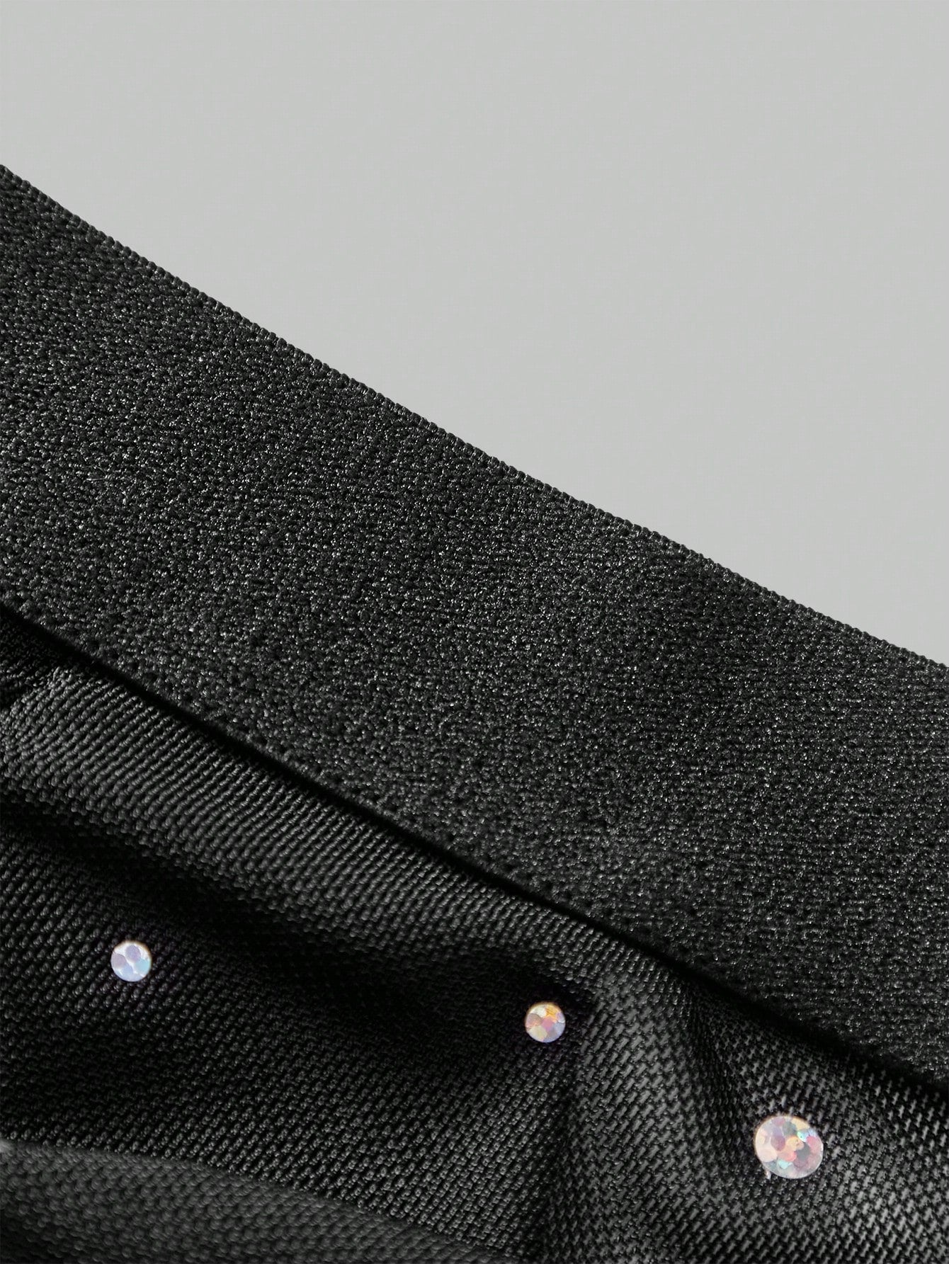 Black men's lingerie briefs with a backless low rise design, plain pattern, and high-stretch knitted fabric for party wear.