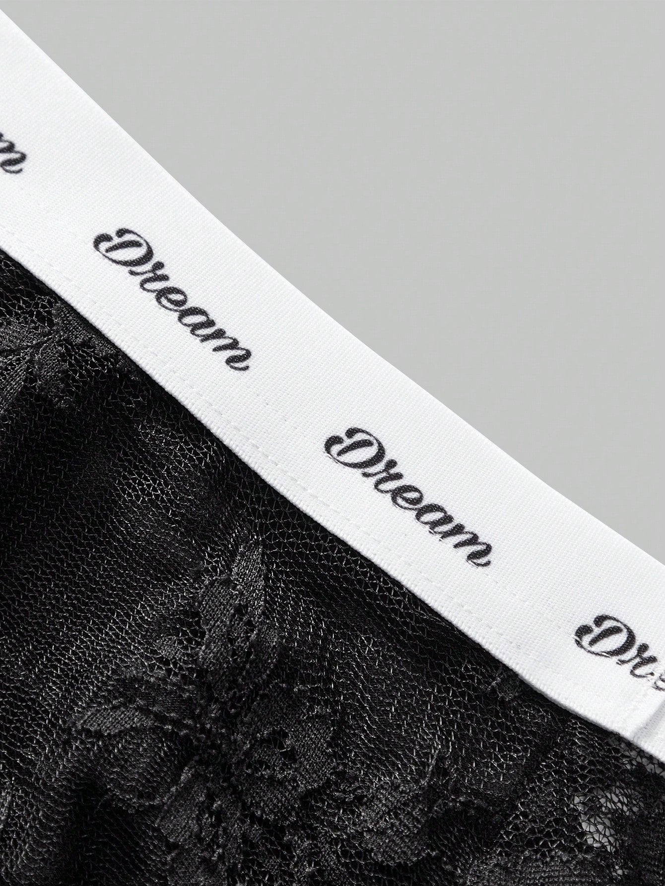 Men's black and white lace trim briefs with letter and plant pattern, regular fit, slight stretch, made from polyamide and elastane.