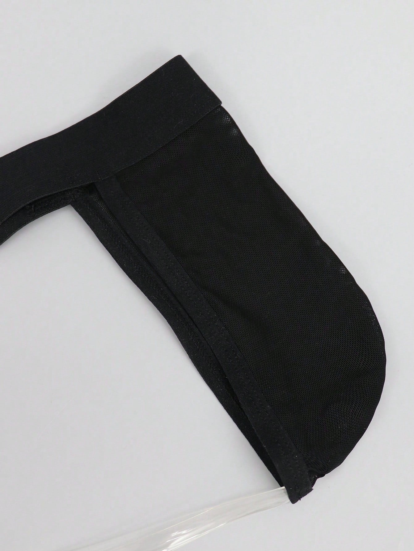 Black men's low rise jockstrap underwear in mesh fabric with colorblock design, medium stretch, and backless crotchless styling.