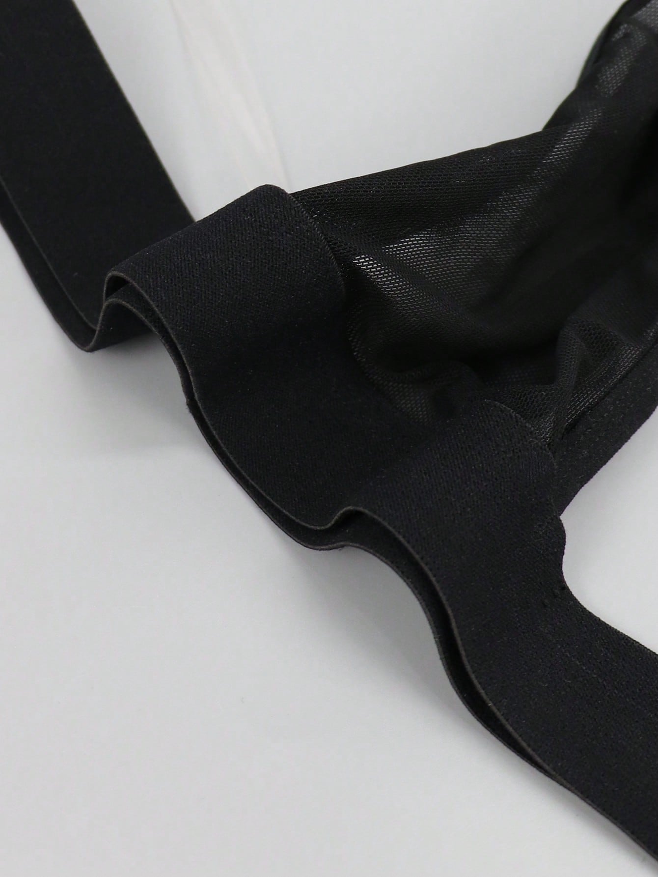 Black men's low rise jockstrap underwear in mesh fabric with colorblock design, medium stretch, and backless crotchless styling.