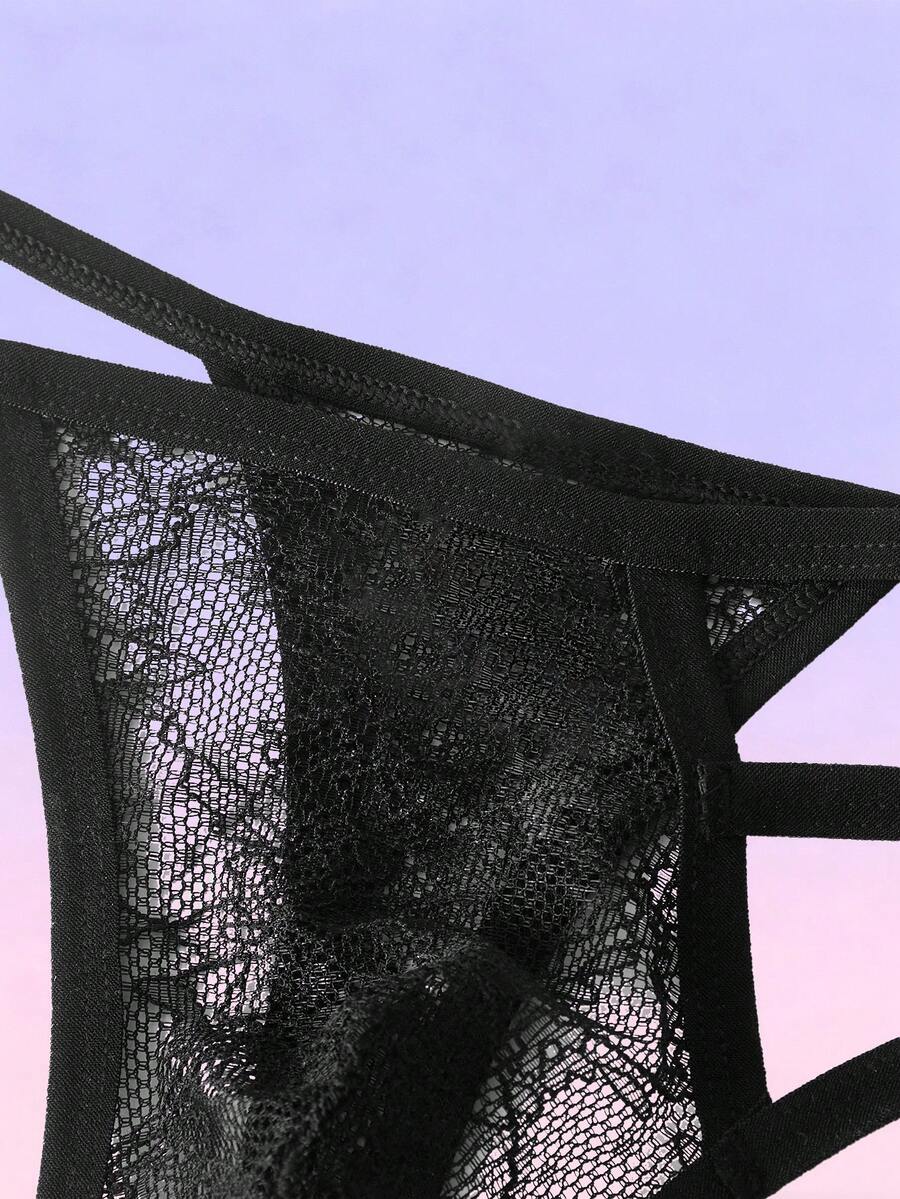 Black men's low-rise lace thong featuring a hollow-out plain design made from a stretch polyamide blend fabric.