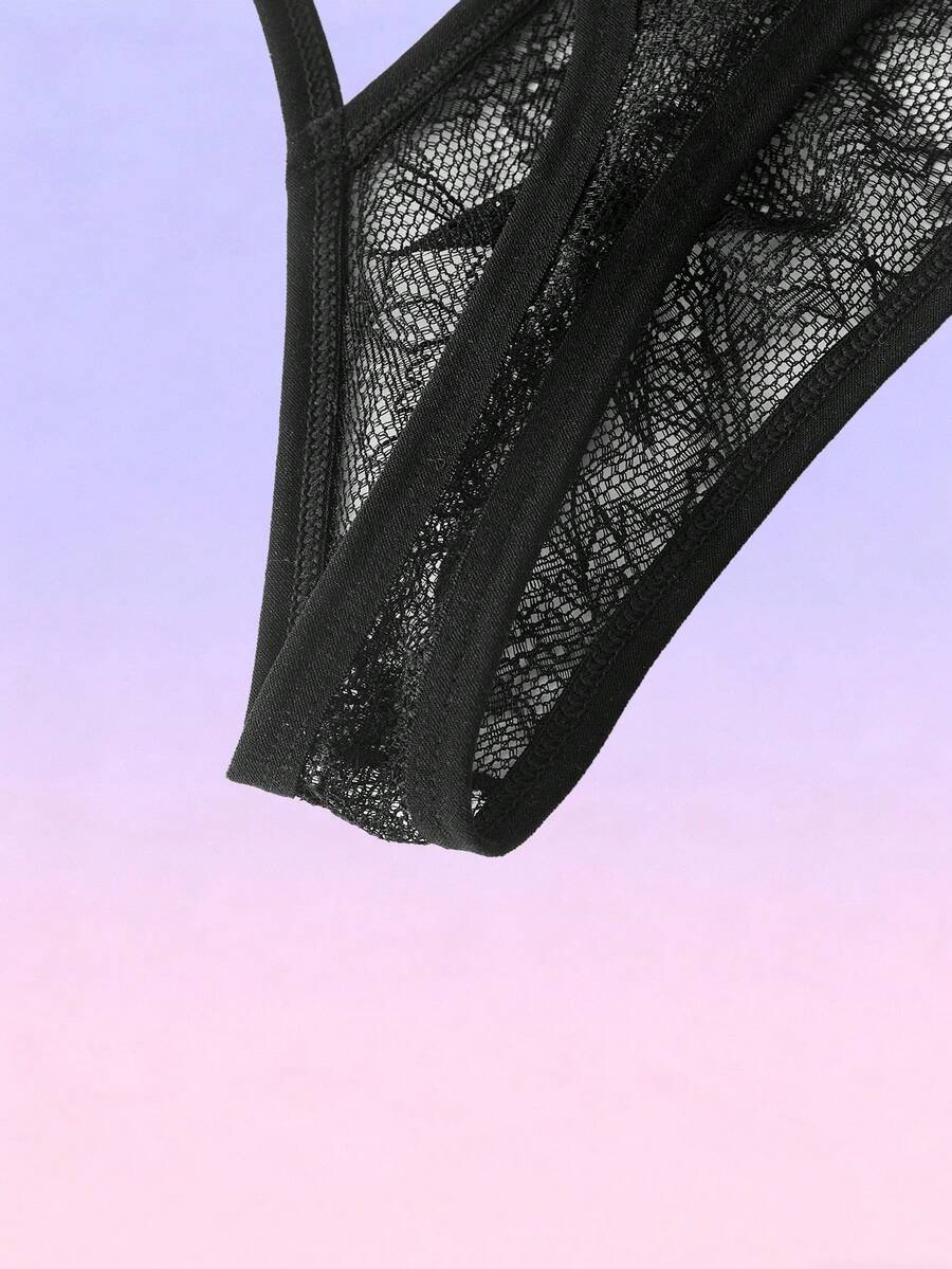 Black men's low-rise lace thong featuring a hollow-out plain design made from a stretch polyamide blend fabric.