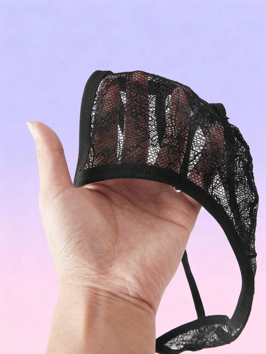 Black men's low-rise lace thong featuring a hollow-out plain design made from a stretch polyamide blend fabric.