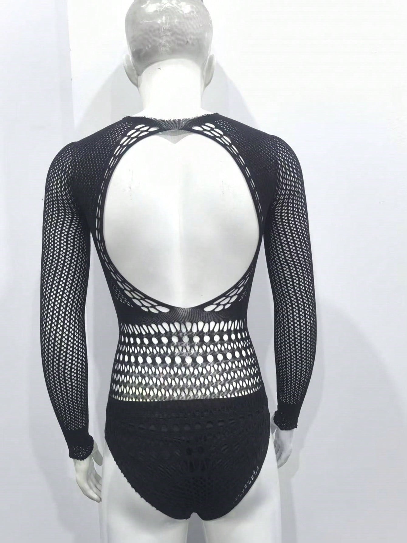 Black fishnet jumpsuit lingerie for men with hollow out detail, sheer knitted fabric, stand collar, high rise fit, and high stretch polyamide construction.