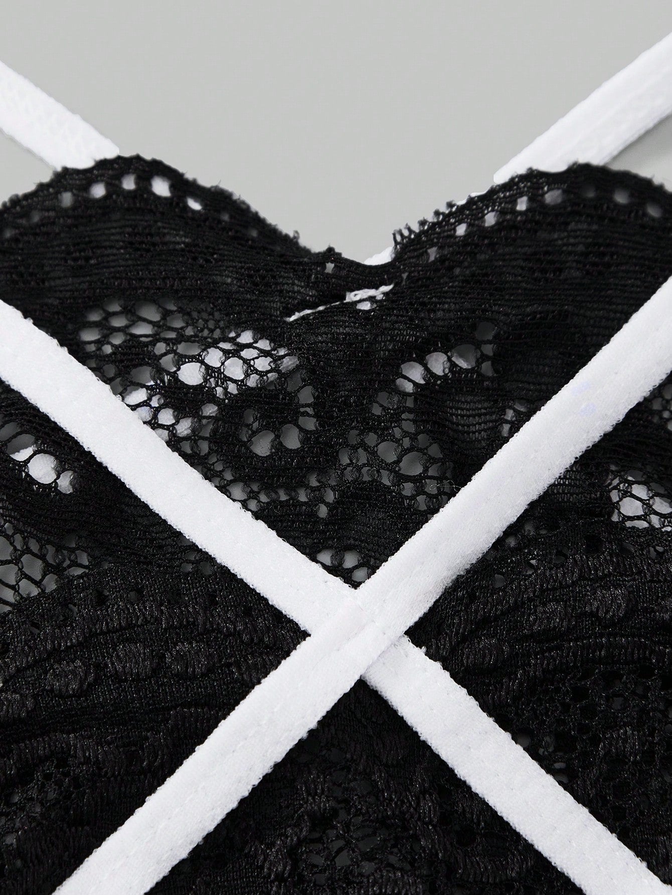 Men's black semi-sheer lace thong underwear with low rise fit, plain pattern, slight stretch fabric, and bowknot ribbon detail.