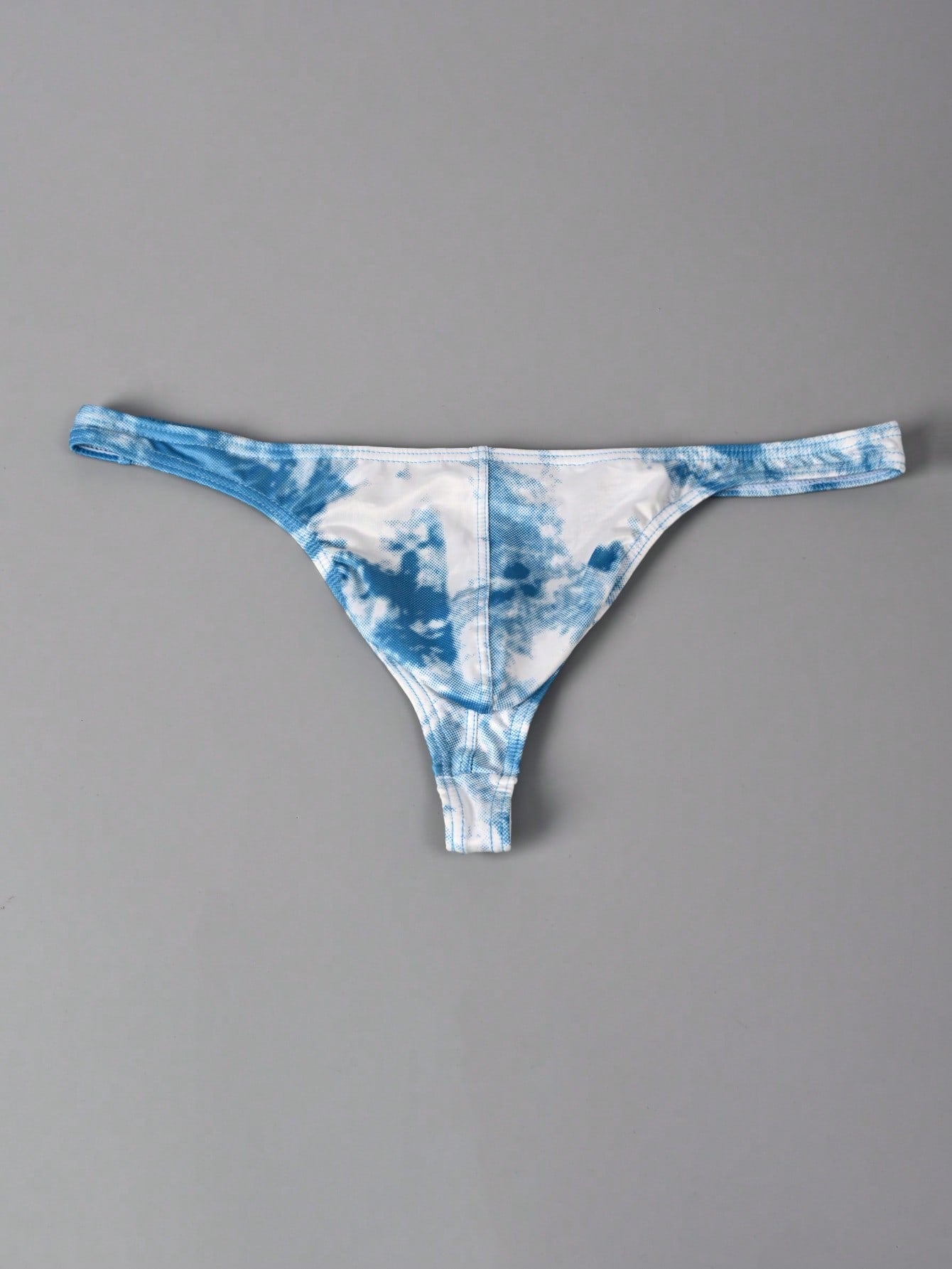 Men's tie dye thong underwear with a low rise fit and T-back design, made from polyester and elastane stretch fabric.