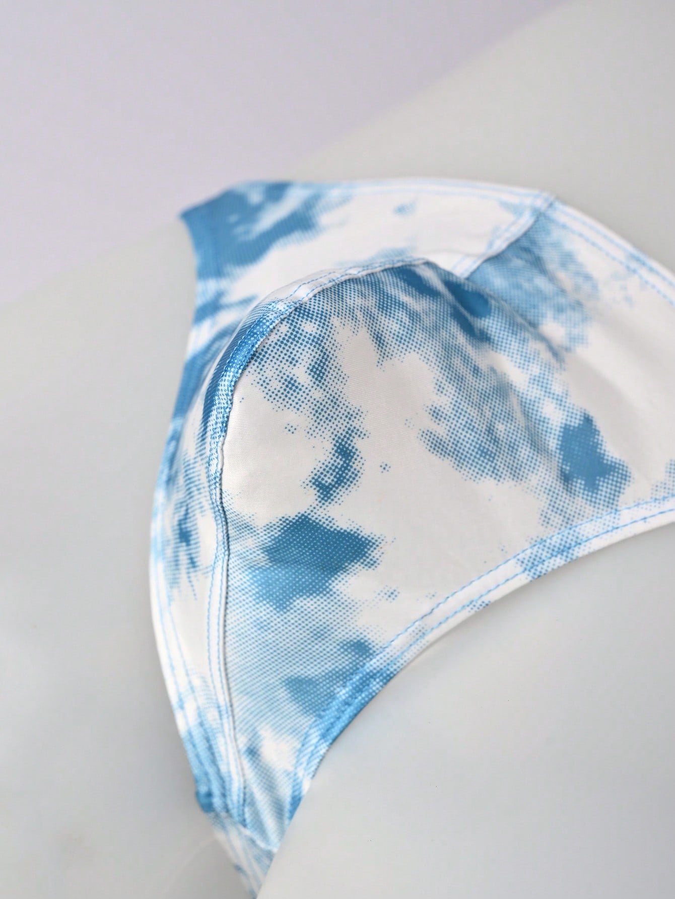 Men's tie dye thong underwear with a low rise fit and T-back design, made from polyester and elastane stretch fabric.