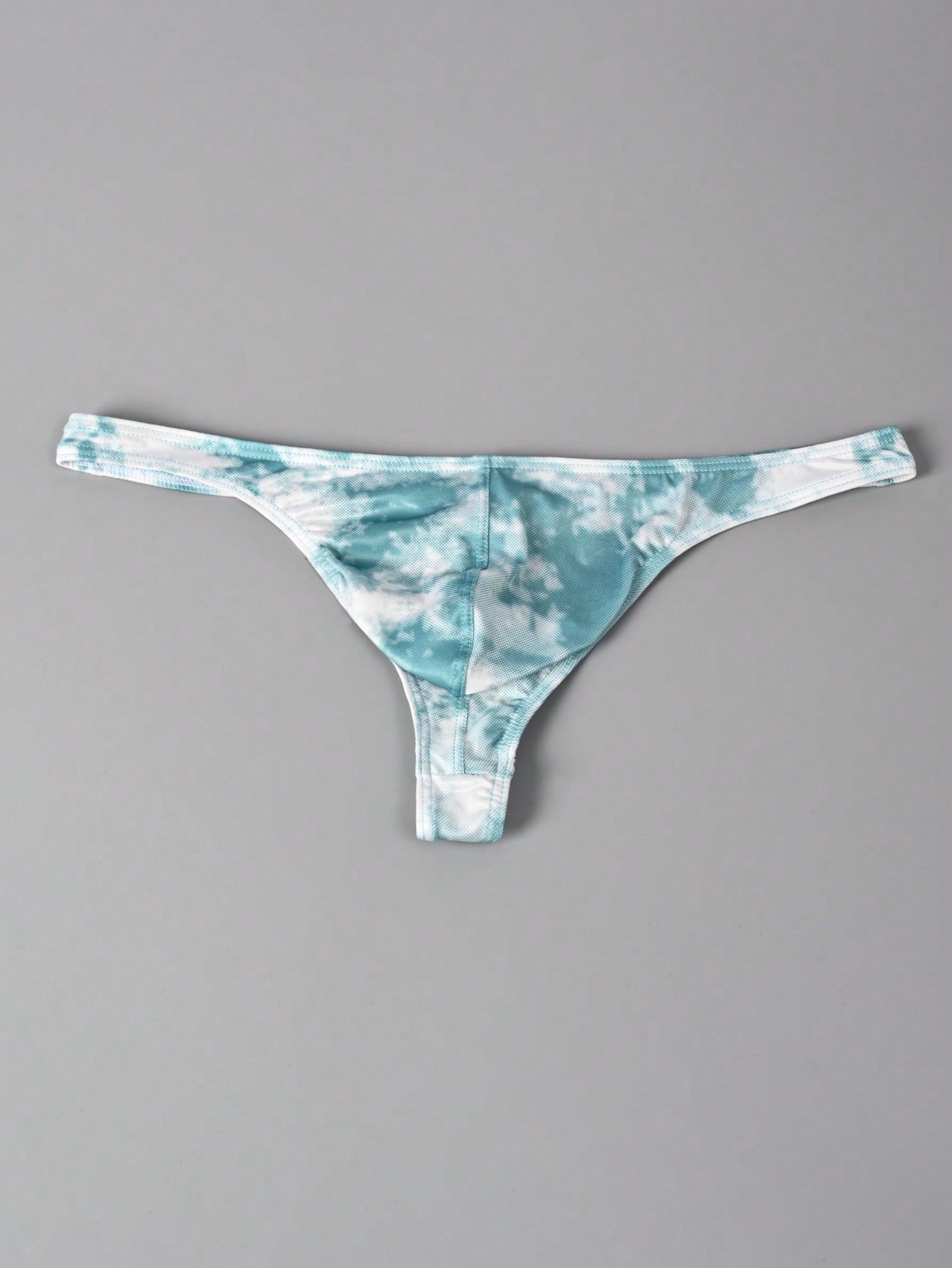 Men's tie dye thong underwear with a low rise fit and T-back design, made from polyester and elastane stretch fabric.