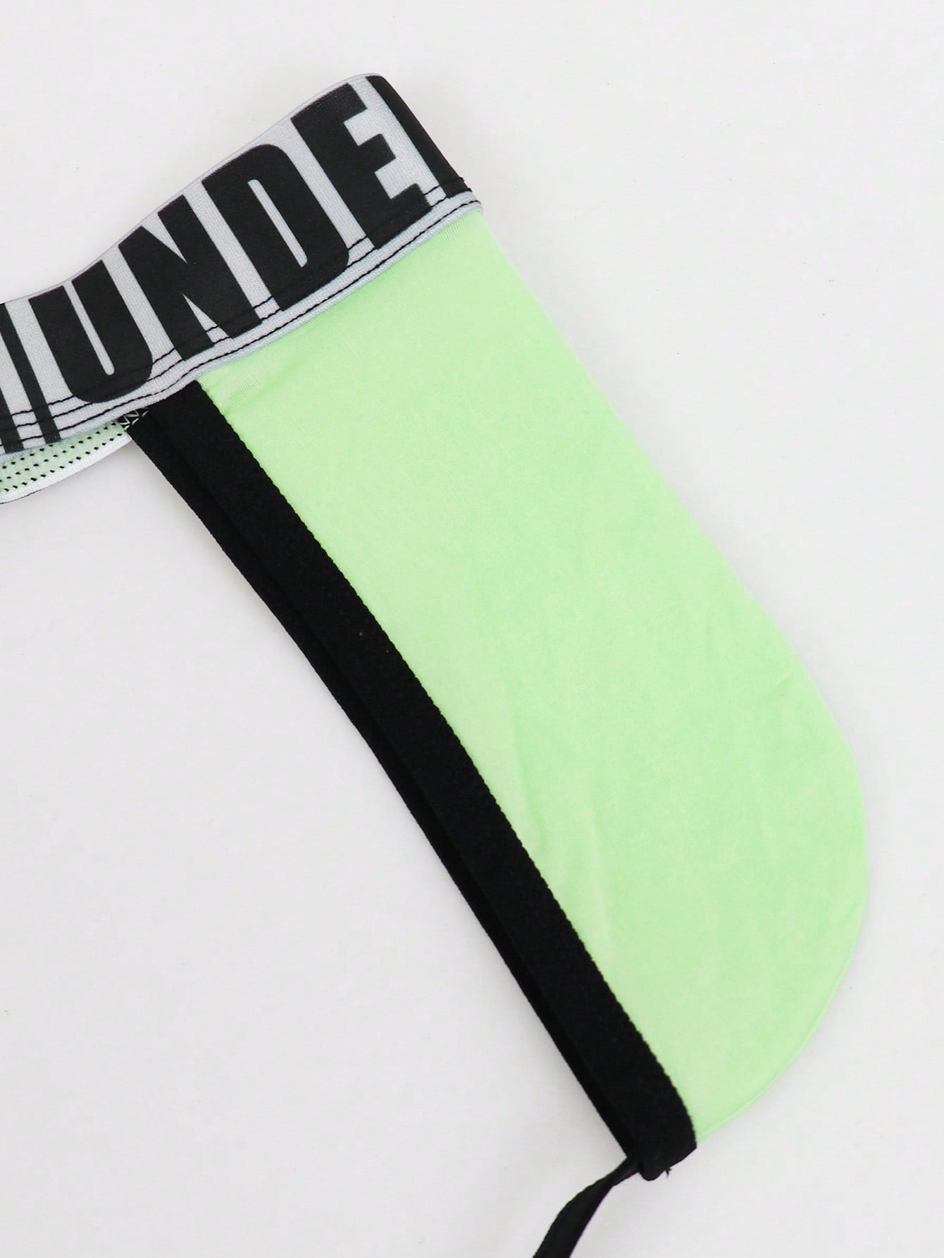 Men's low rise thong underwear in knitted fabric with striped colorblock pattern and letter waistband.