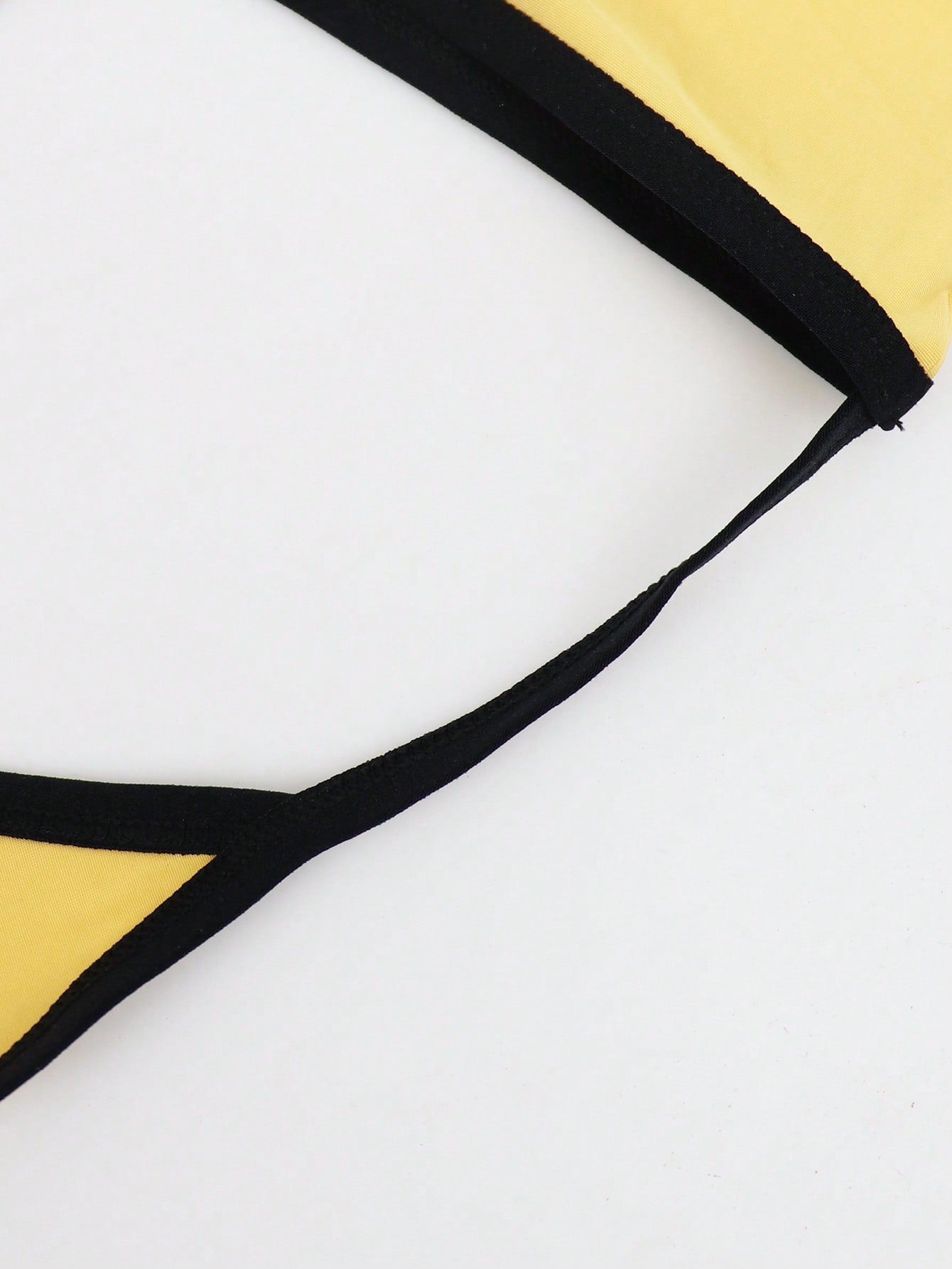 Men's low rise thong underwear in knitted fabric with striped colorblock pattern and letter waistband.
