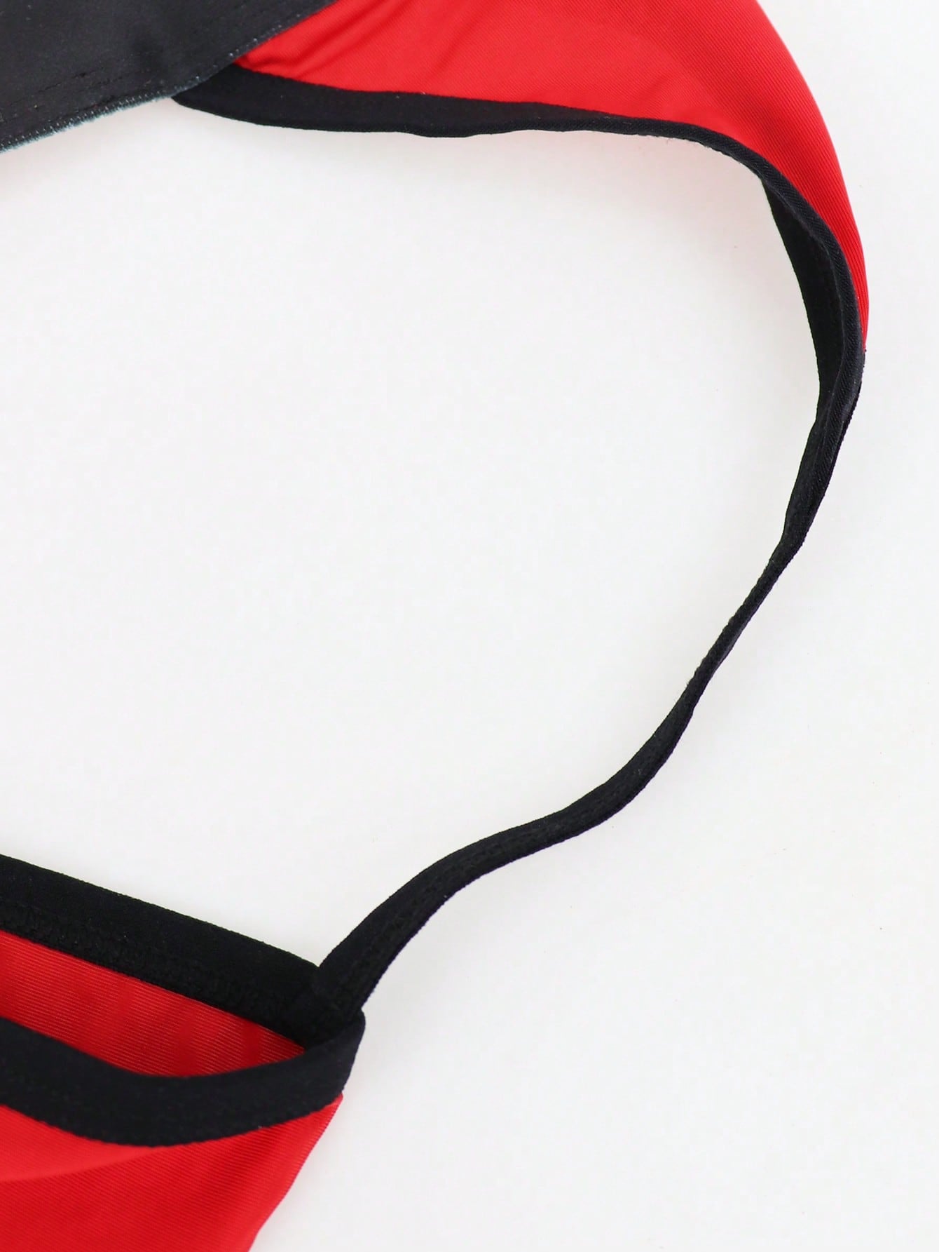 Men's low rise thong underwear in knitted fabric with striped colorblock pattern and letter waistband.