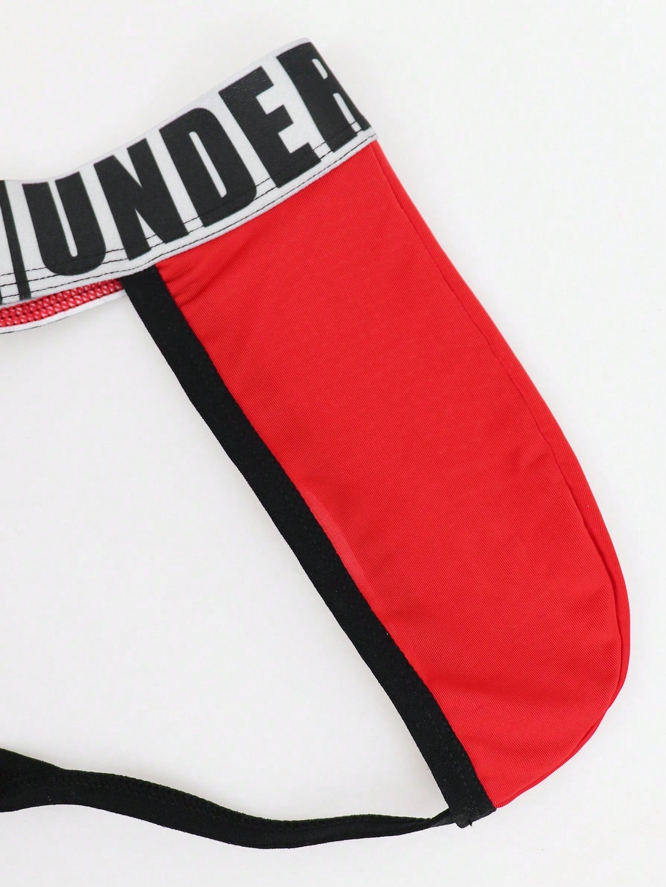 Men's low rise thong underwear in knitted fabric with striped colorblock pattern and letter waistband.