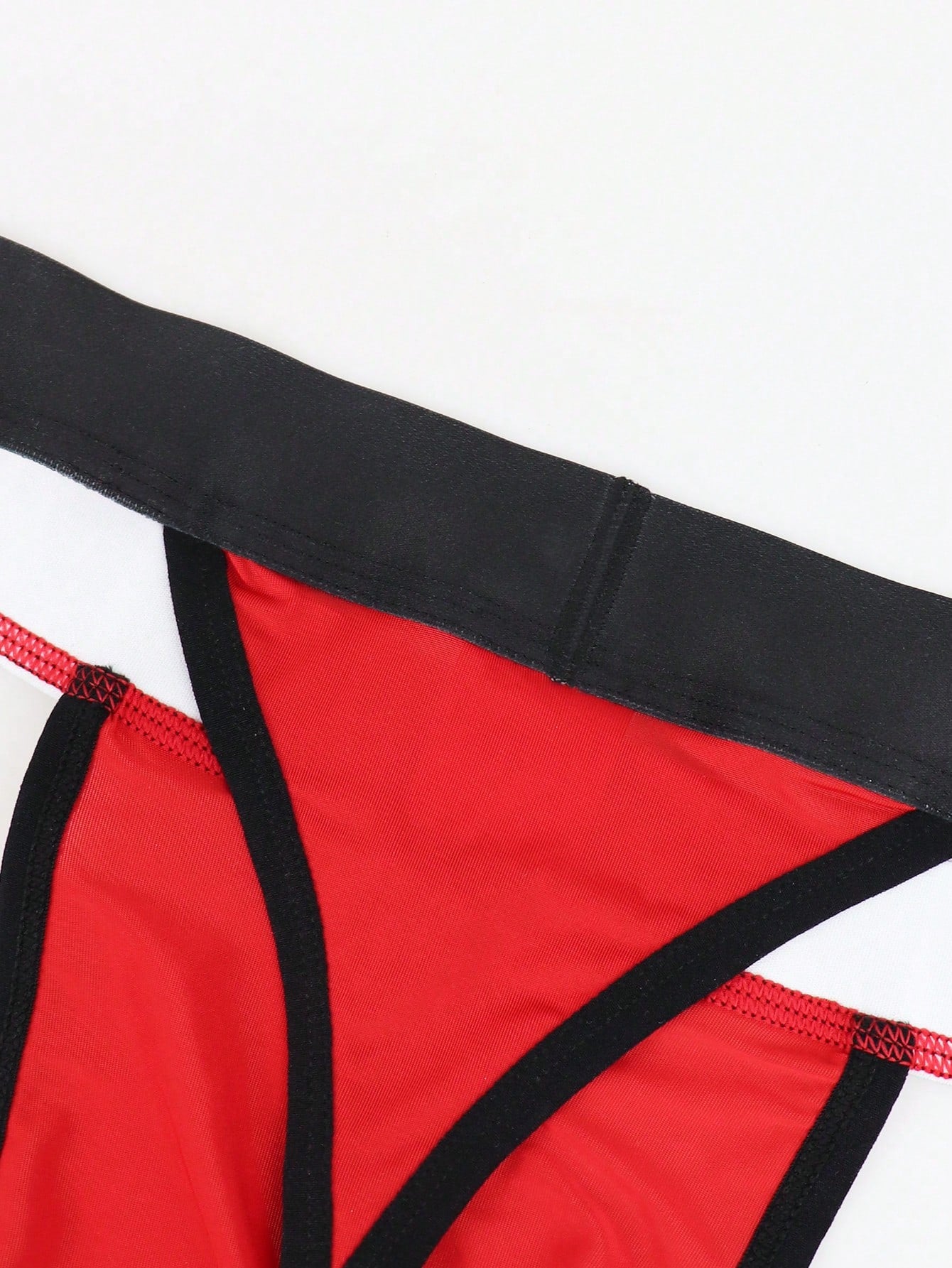 Men's low rise thong underwear in knitted fabric with striped colorblock pattern and letter waistband.