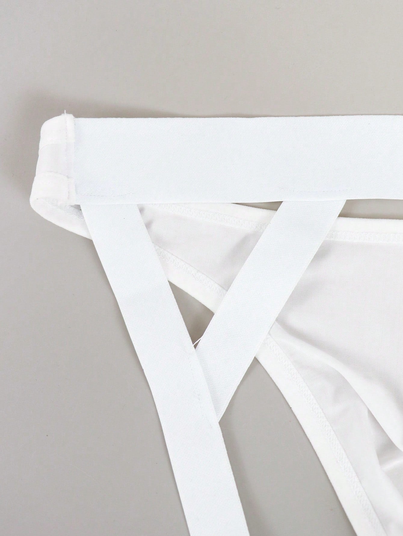 Men's solid color jockstrap underwear in knitted fabric with a breathable hollow design, low rise fit, plain pattern, and medium stretch for daily wear.