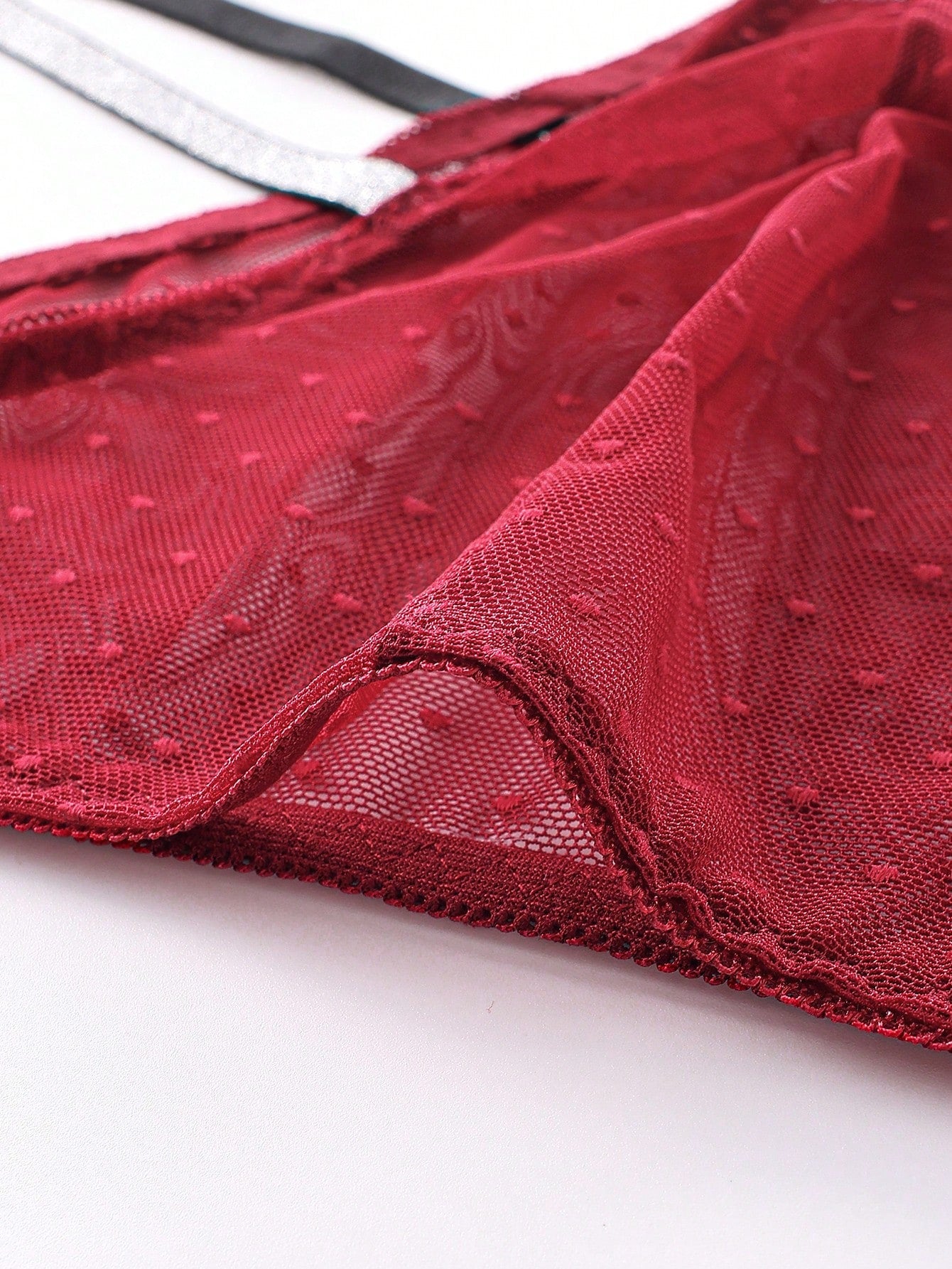 Men's low rise briefs in burgundy knitted fabric with lace trim, geometric pattern, medium stretch, and a semi-sheer finish.