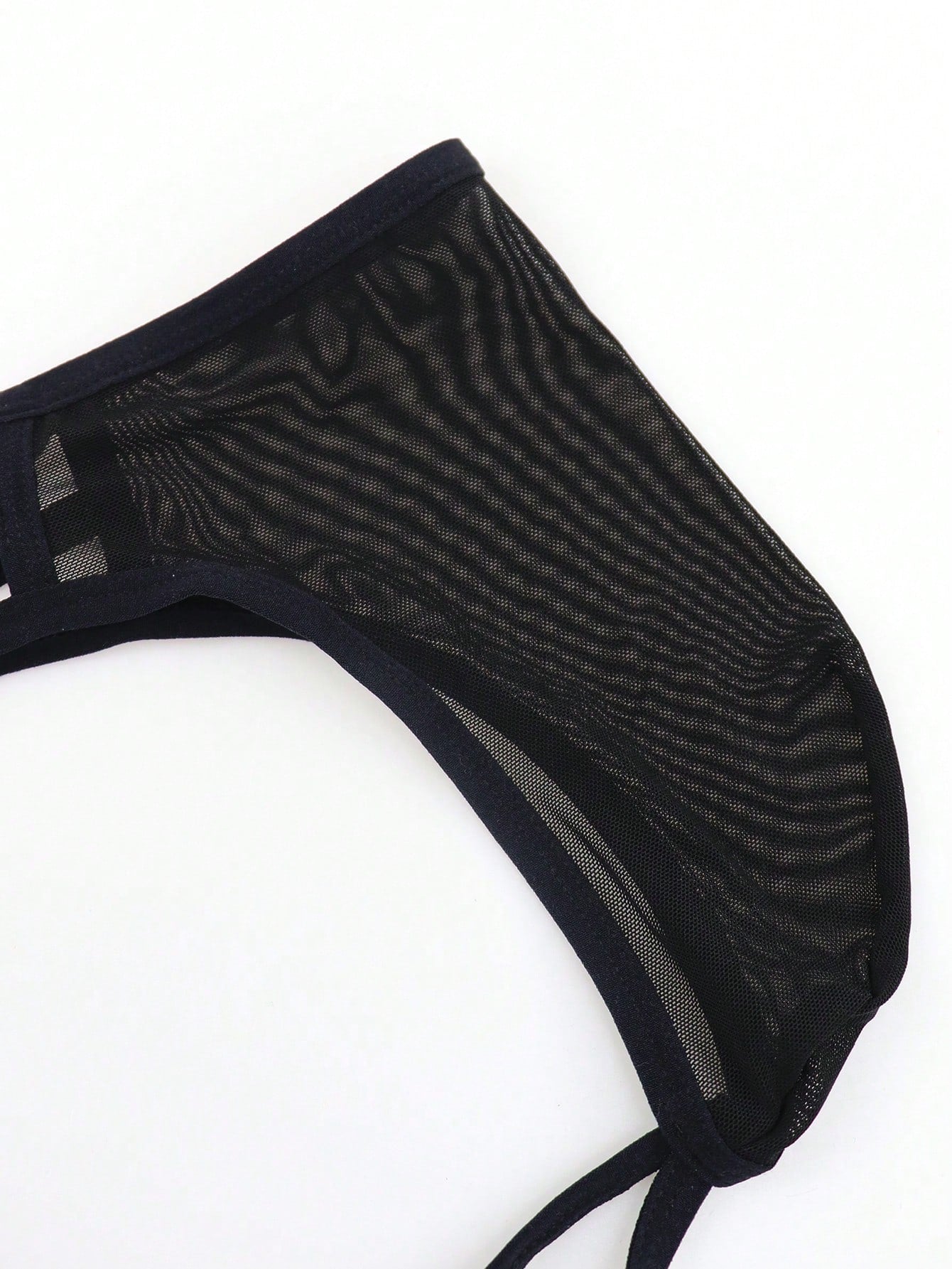 Black men's criss-cross mesh thong underwear with low rise V-string design and medium stretch fabric.