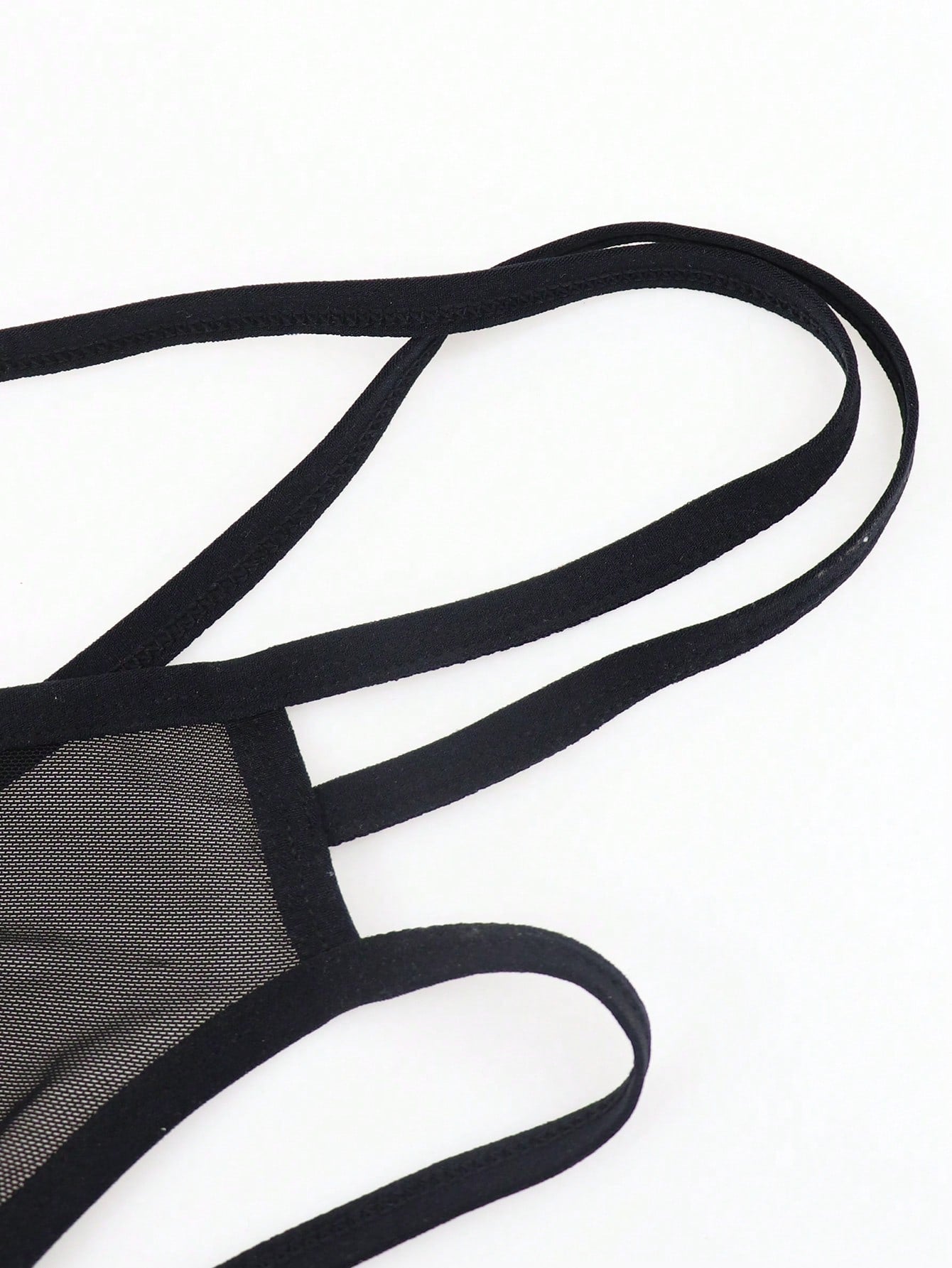 Black men's criss-cross mesh thong underwear with low rise V-string design and medium stretch fabric.