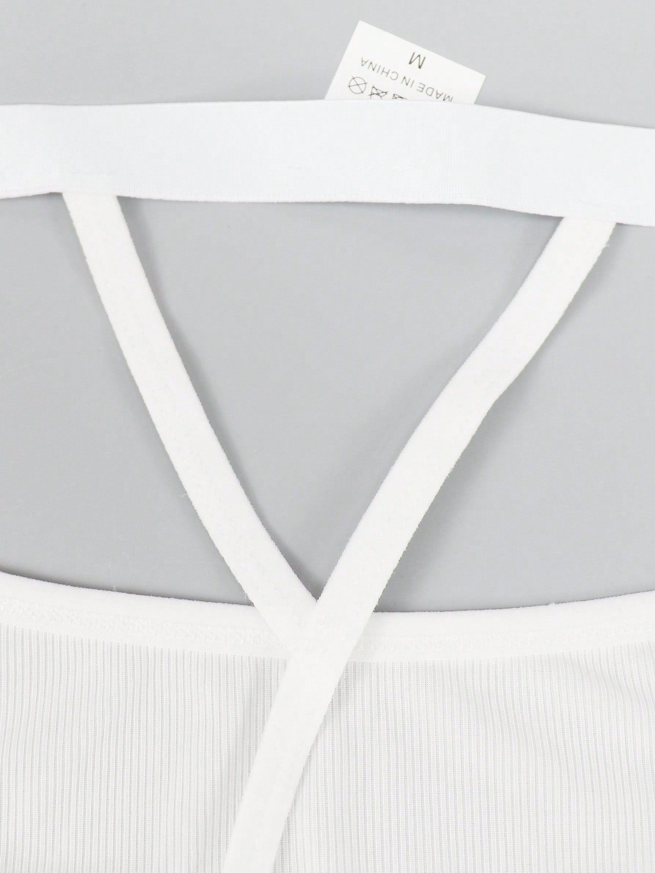 Men's black low rise thong briefs with cut out detail, plain pattern, and medium stretch knitted fabric
