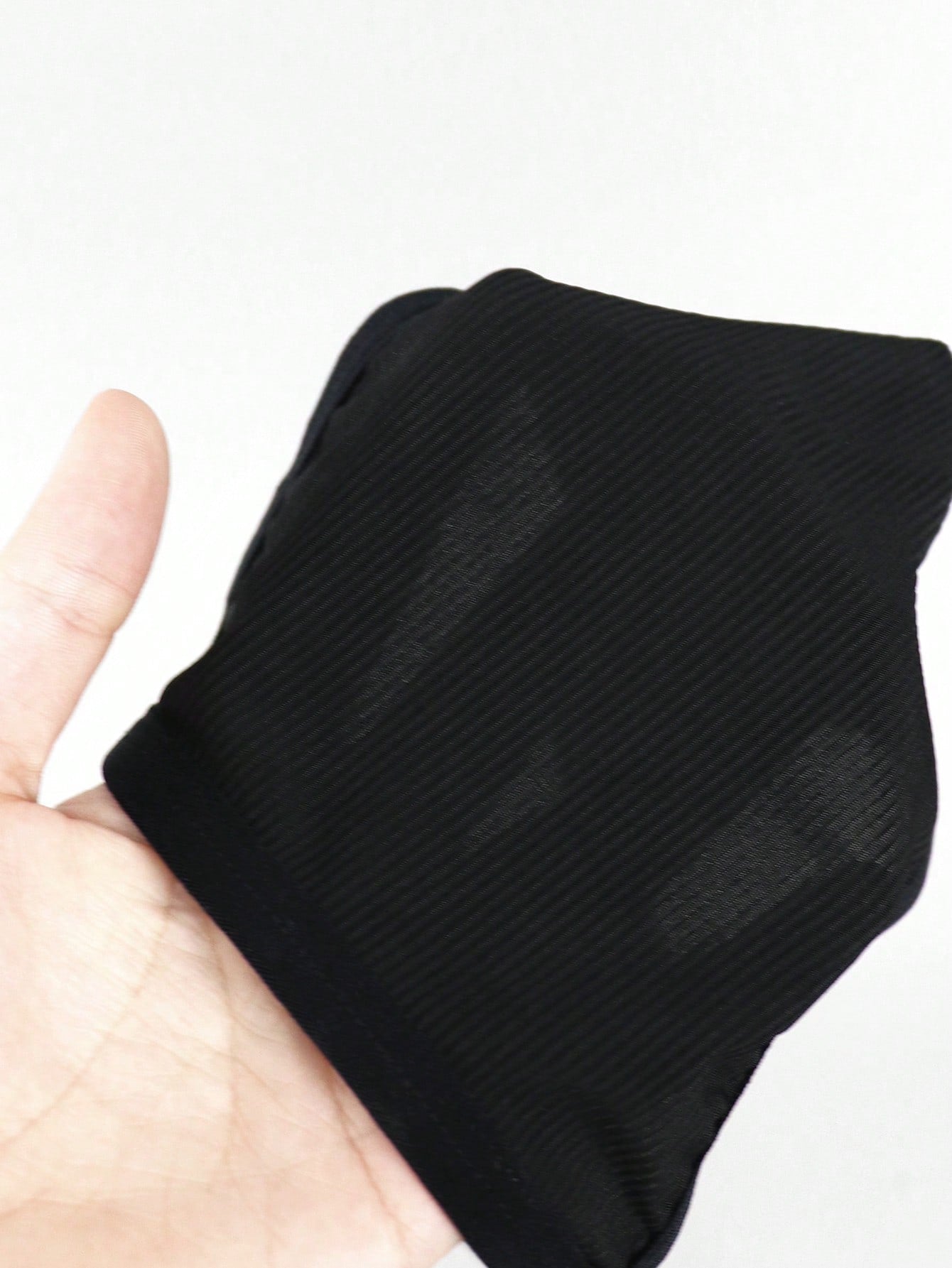 Men's black low rise thong briefs with cut out detail, plain pattern, and medium stretch knitted fabric