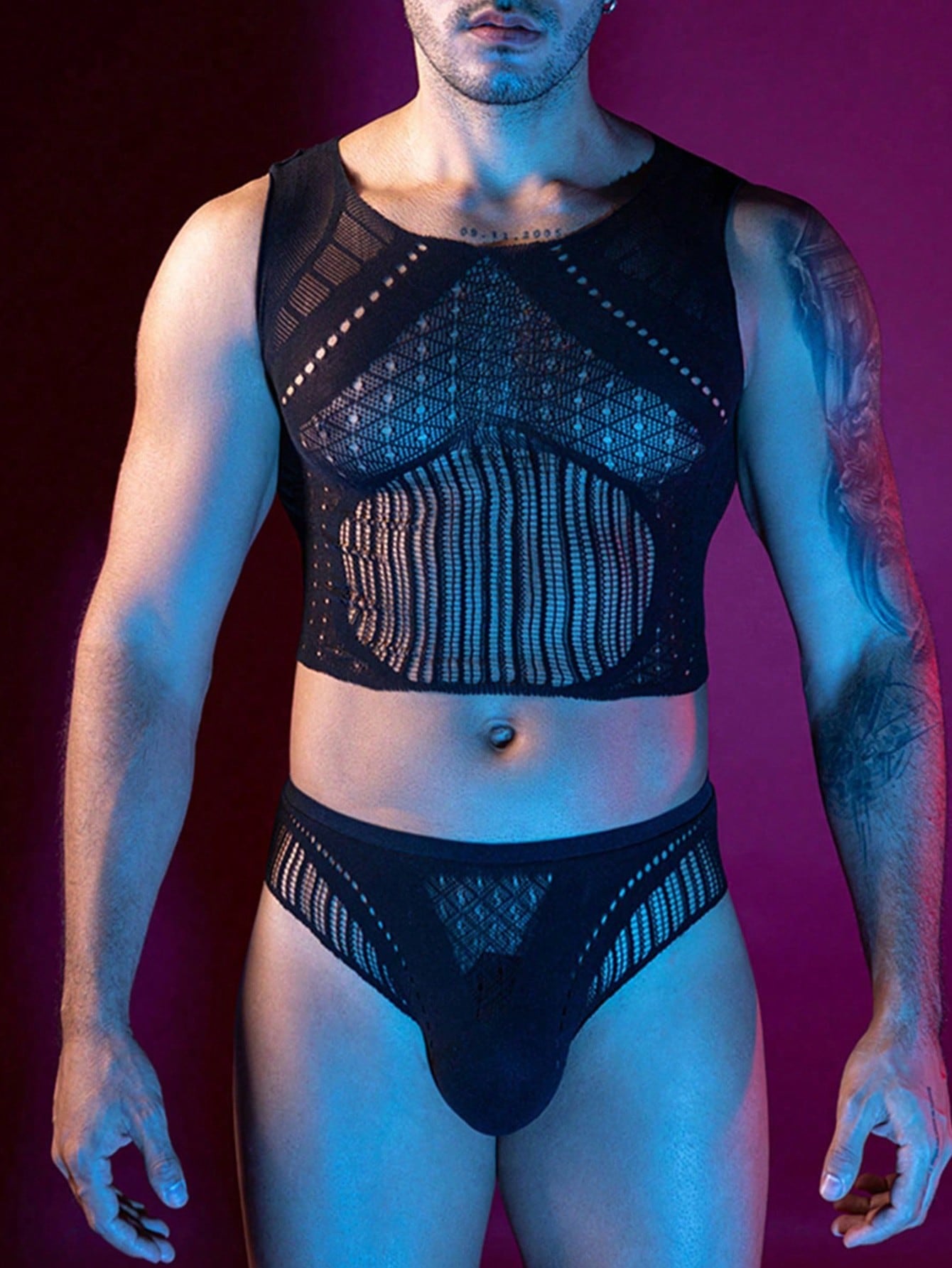 Men's black hollow-out mesh lingerie set with a cropped sleeveless tank top and matching briefs, featuring a round neck, backless design, sheer knitted fabric, and slim fit.