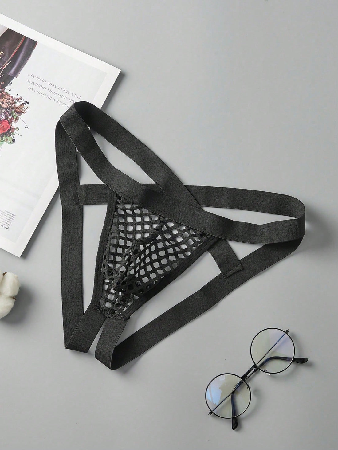 Black men's low rise thong underwear in semi-sheer mesh tulle with geometric pattern and criss cross cut-out detail.