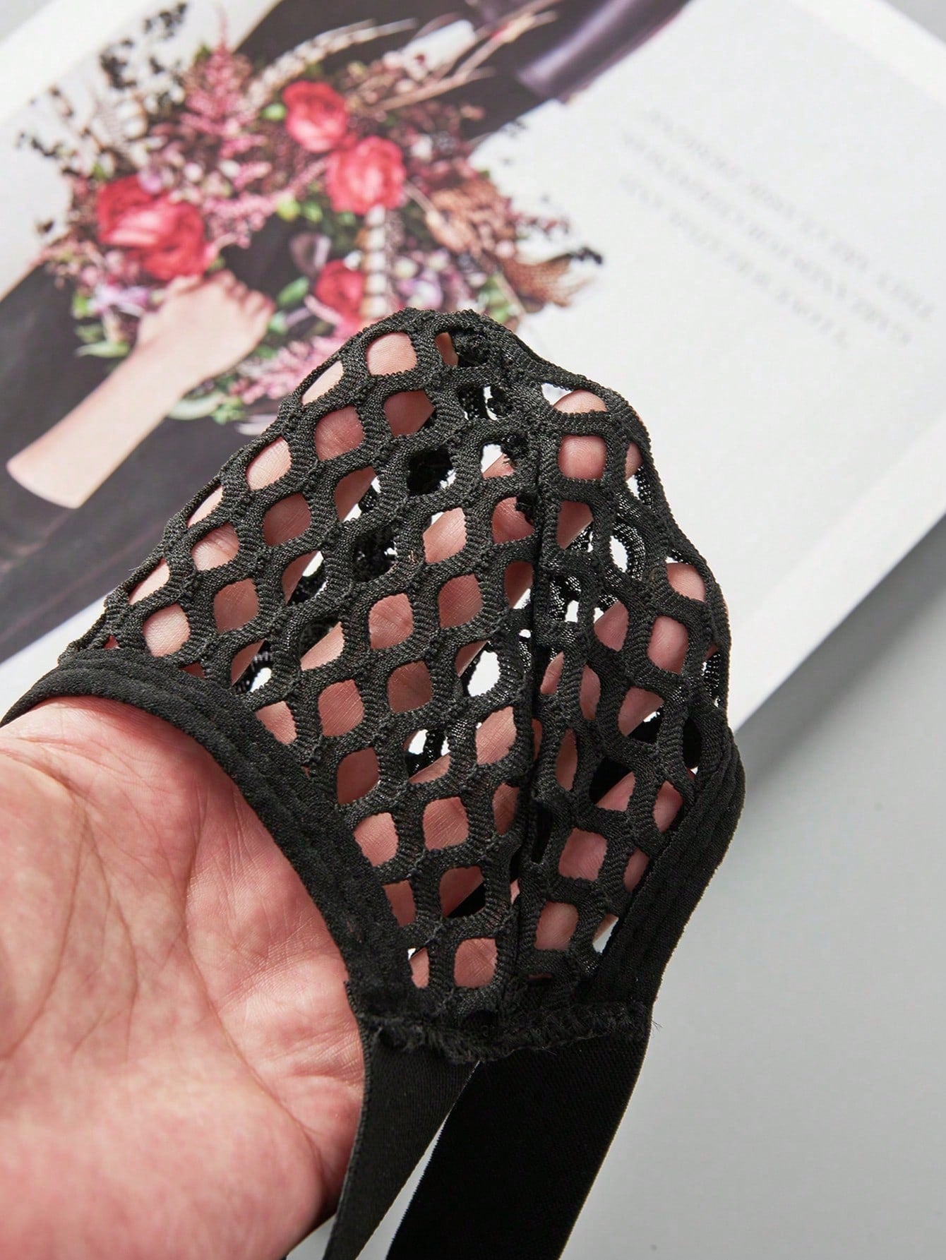 Black men's low rise thong underwear in semi-sheer mesh tulle with geometric pattern and criss cross cut-out detail.