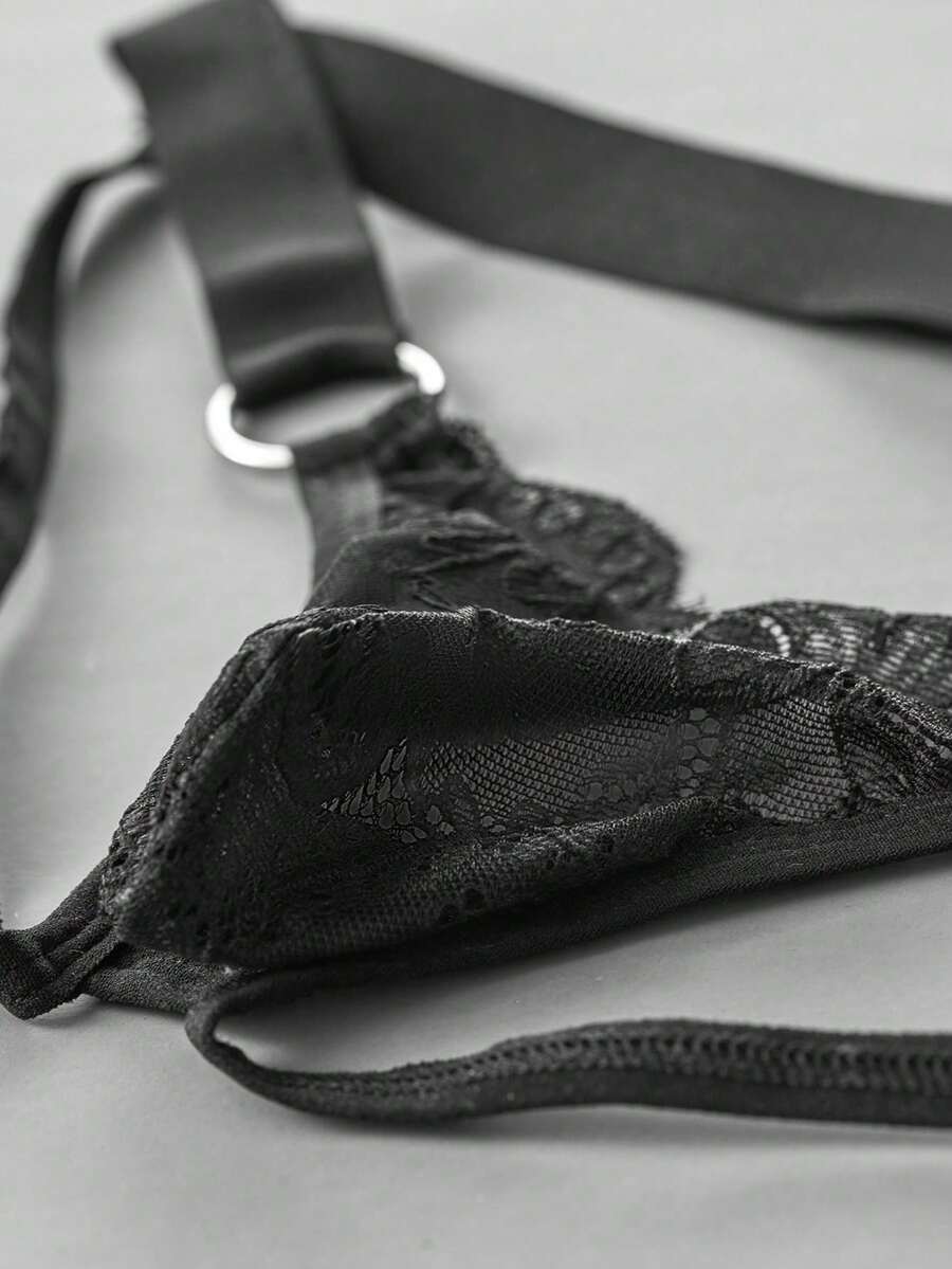 Black men's low-rise lace jockstrap underwear featuring hollow-out details and semi-sheer fabric.