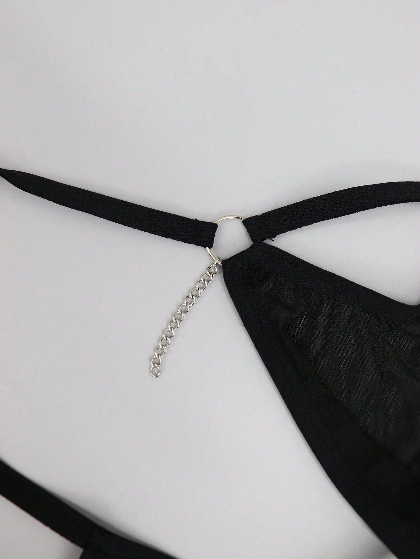 Men's black low rise mesh thong underwear with chain detail and colorblock design.