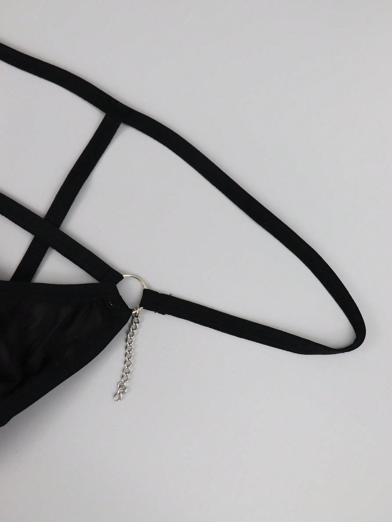 Men's black low rise mesh thong underwear with chain detail and colorblock design.