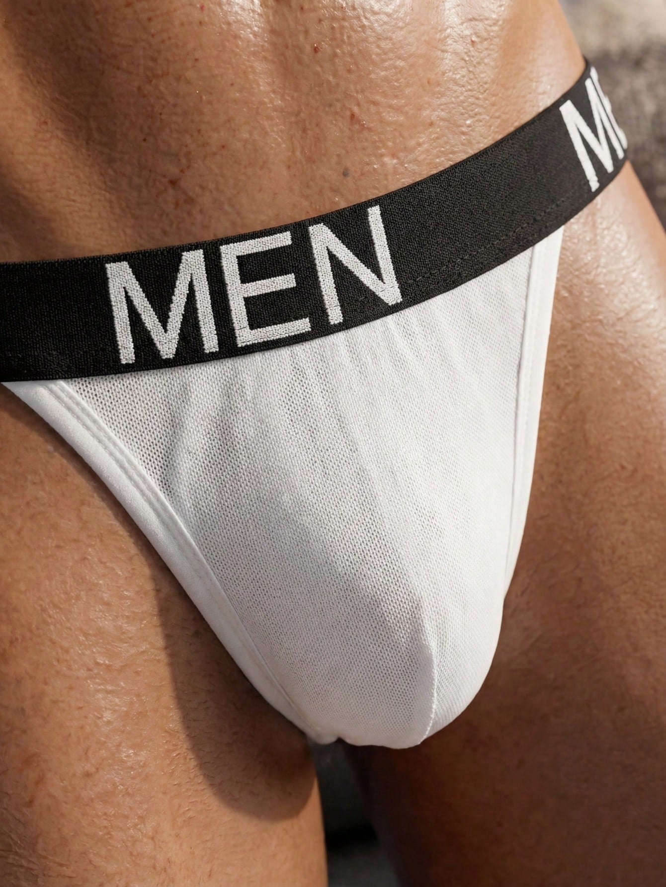 Men's low rise mesh jockstrap underwear with letter pattern, medium stretch fabric, made from 92% polyamide and 8% elastane.