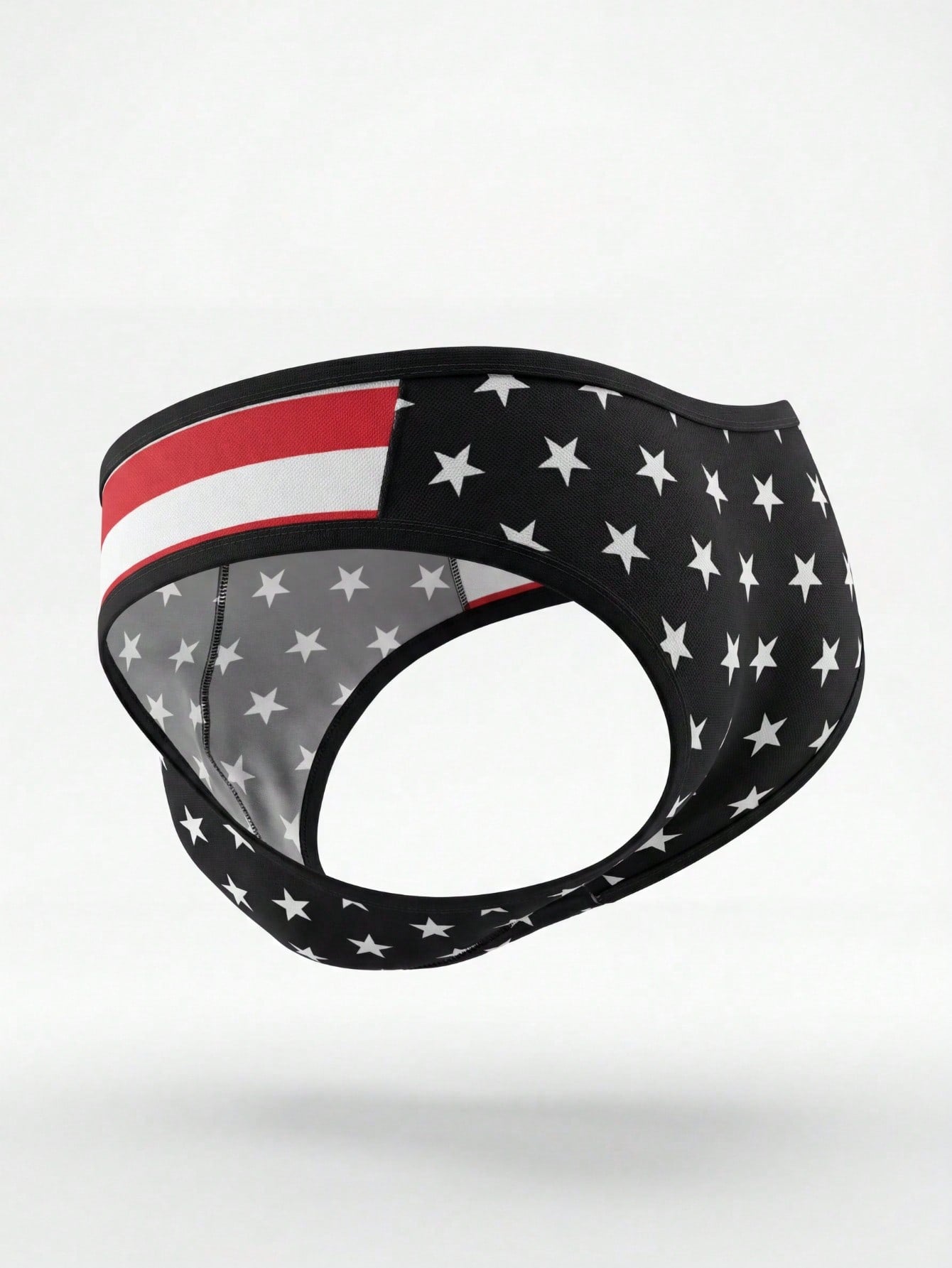 Men's black low rise thong underwear with geometric striped star print in high-stretch knitted fabric.