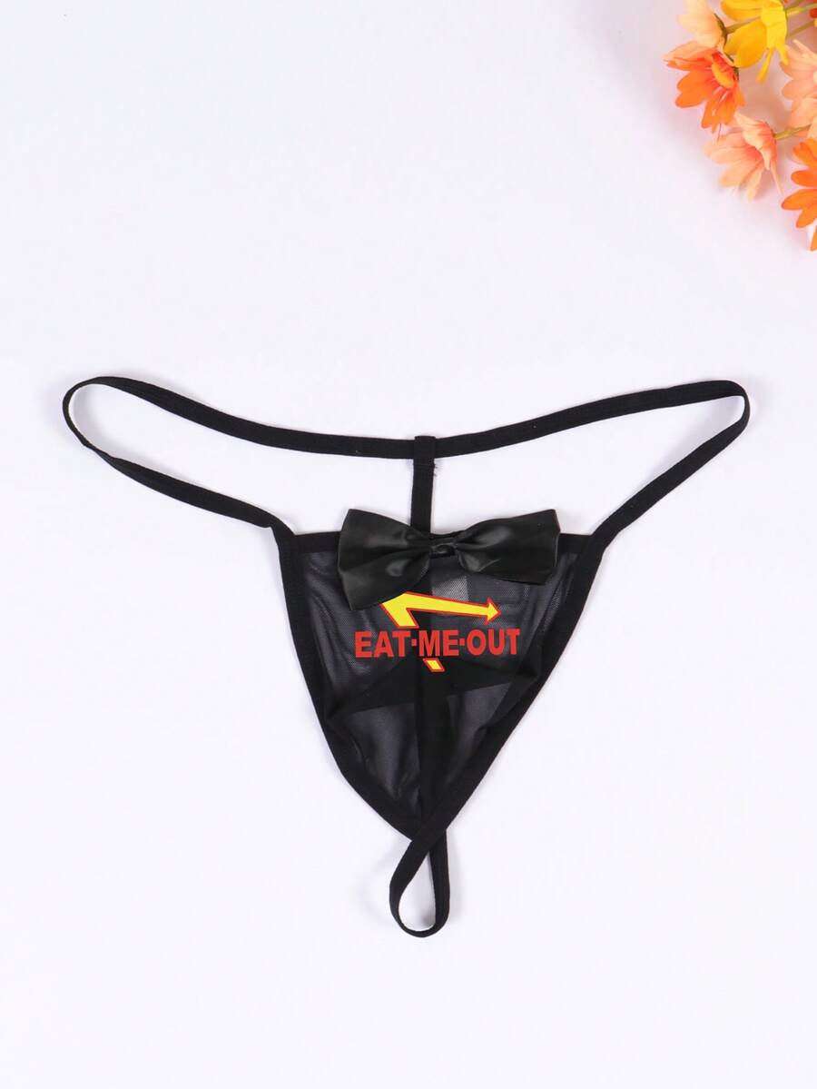 Black men's low rise open crotch G-string thong featuring letter print, bow decor, ring accent, and high stretch semi-sheer fabric.