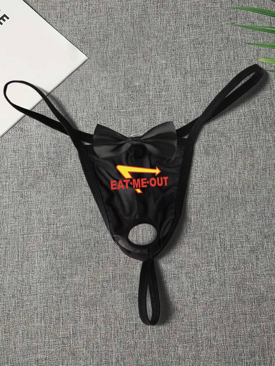 Black men's low rise open crotch G-string thong featuring letter print, bow decor, ring accent, and high stretch semi-sheer fabric.