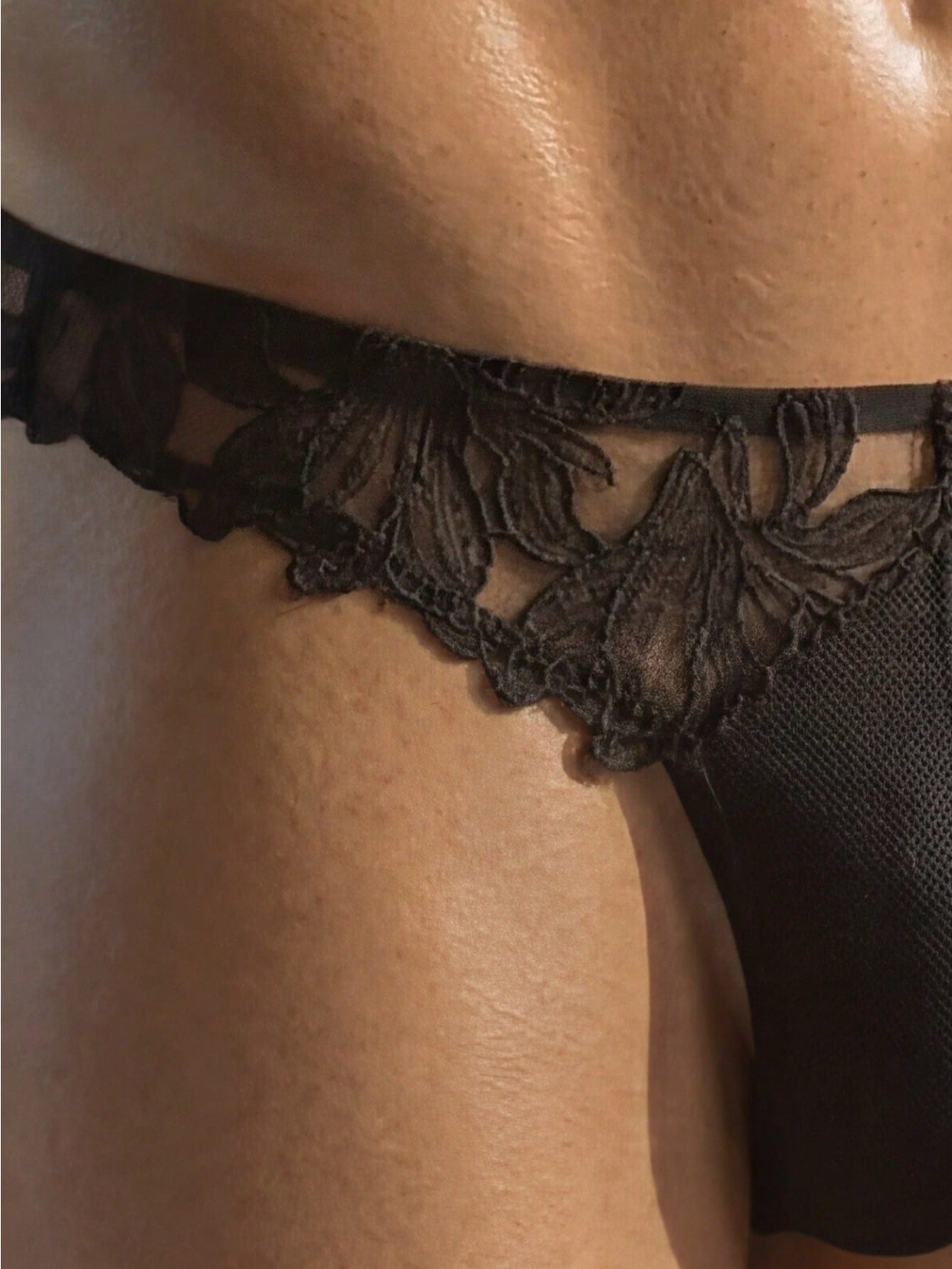 Black men's costume underwear with lace patchwork, plain design, short length, and slight-stretch knitted fabric.