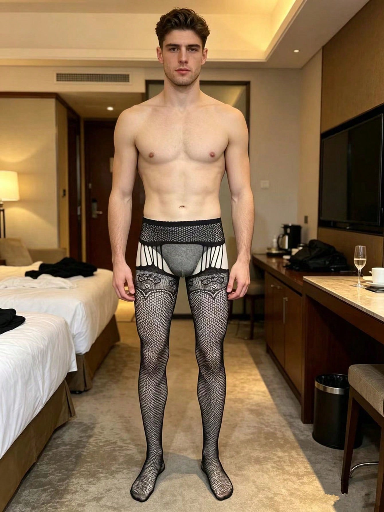Men's fishnet bodystocking in black sheer knitted polyamide with hollow out detail, high stretch fabric, low rise design, and crotchless styling for party wear.