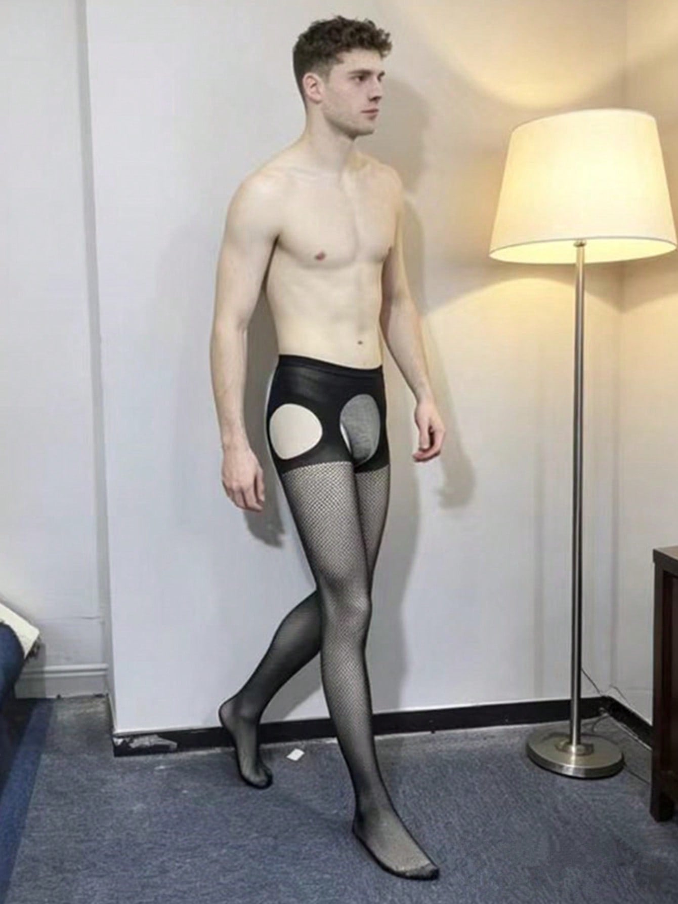 Black sheer fishnet bodystocking for men in high-stretch knitted polyamide with a low-rise thong design and plain pattern.