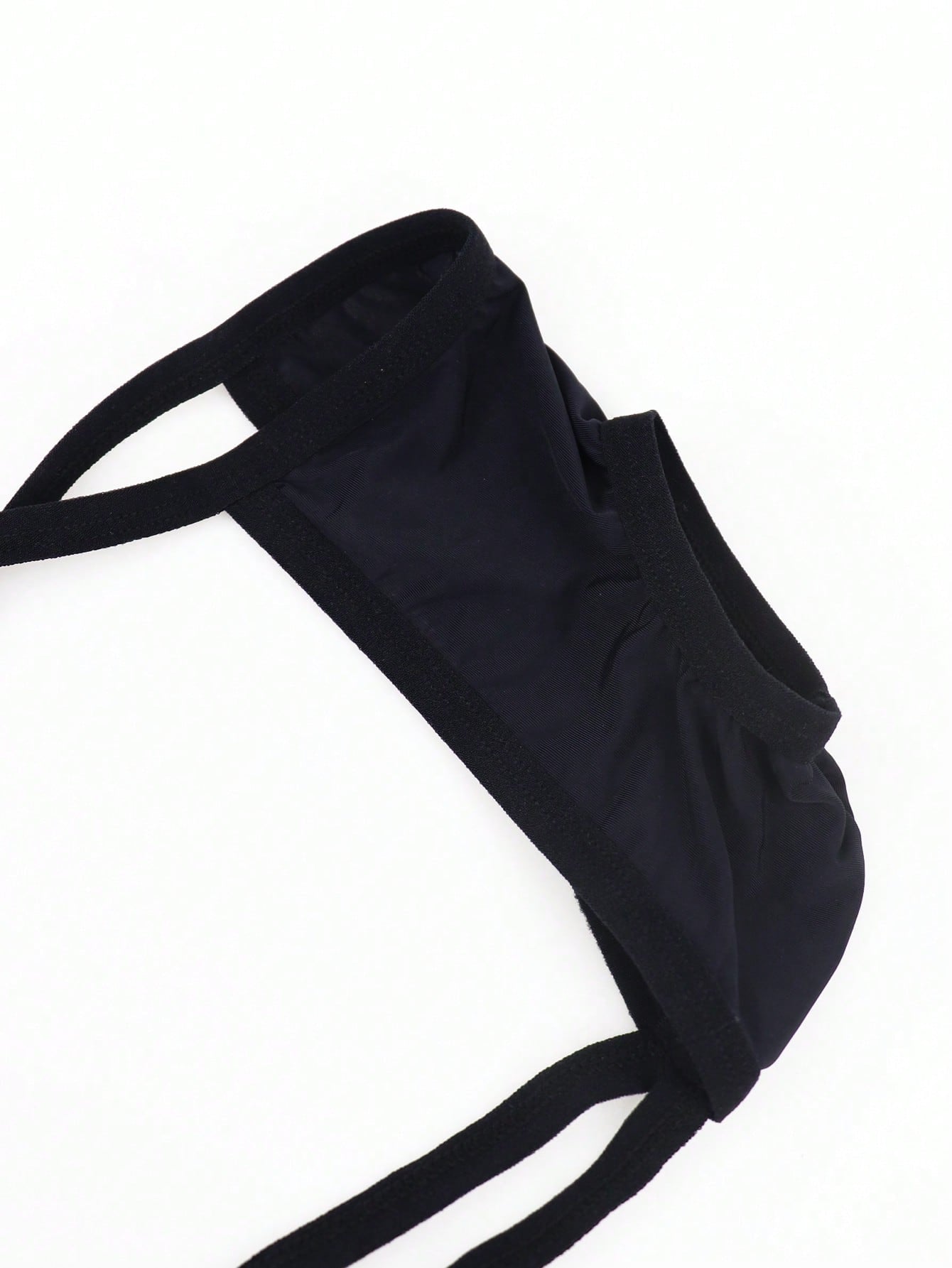 Black men's low-rise thong underwear made from breathable knitted fabric with medium stretch and a plain opaque design.