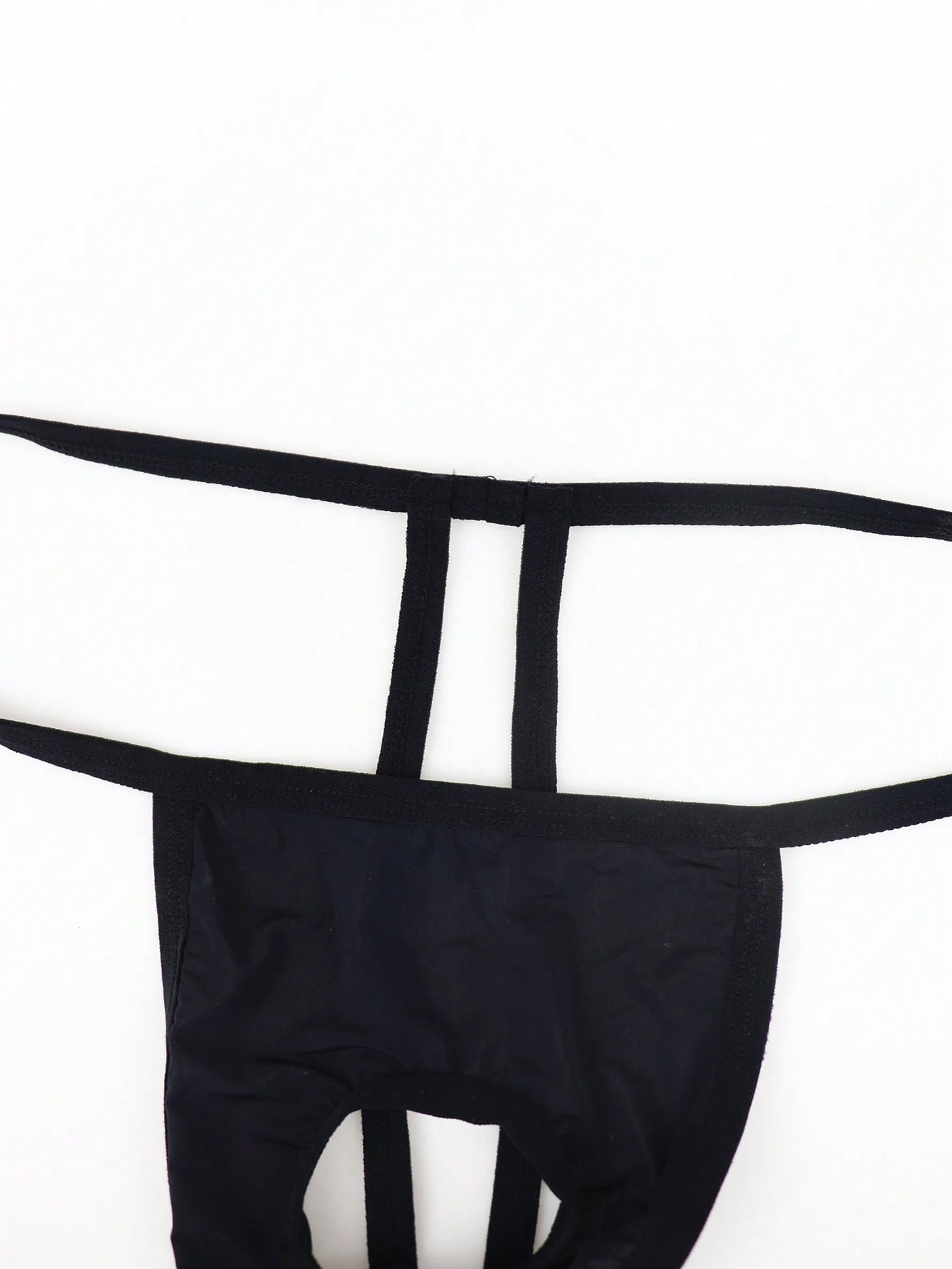 Black men's low-rise thong underwear made from breathable knitted fabric with medium stretch and a plain opaque design.