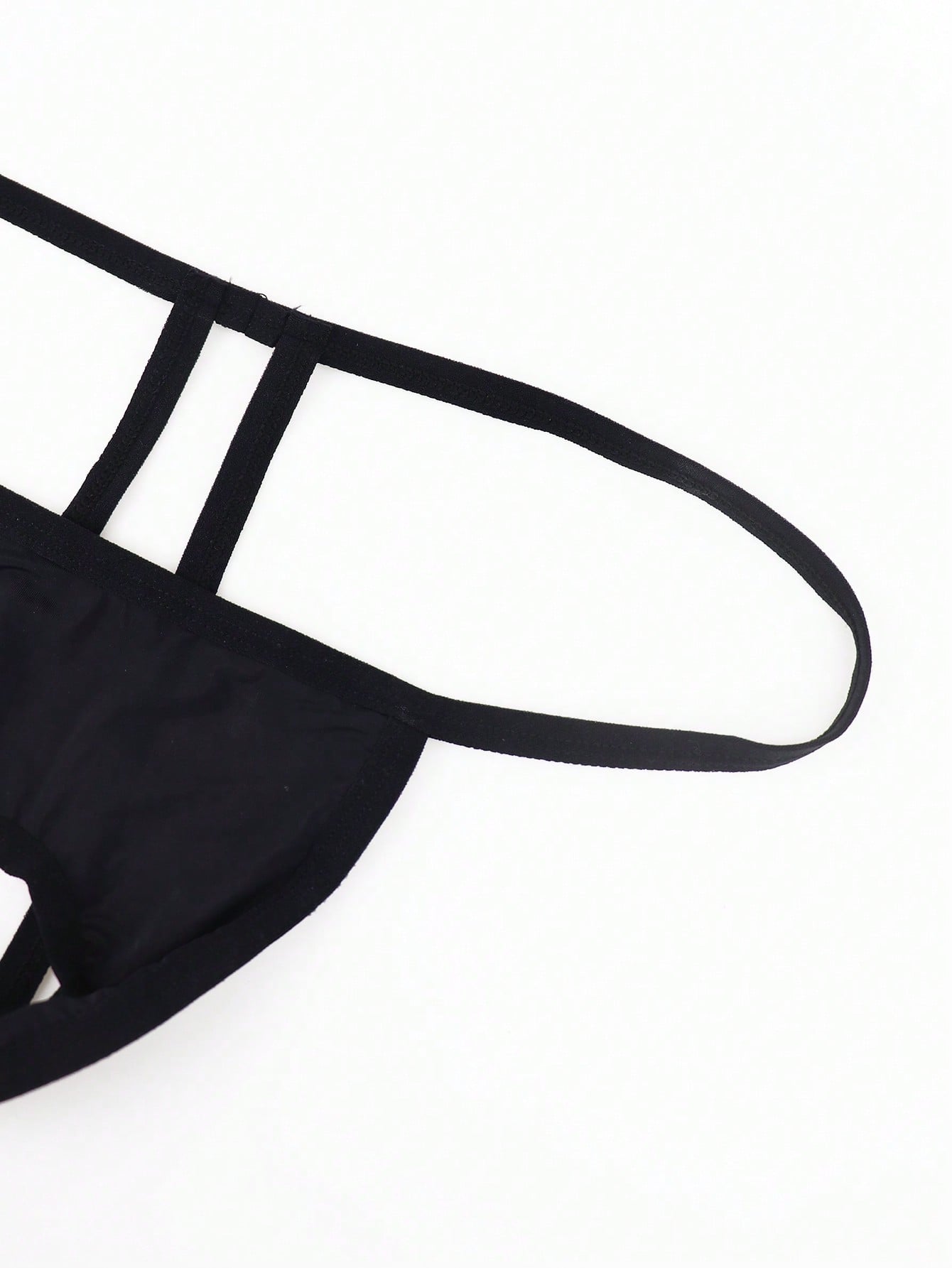 Black men's low-rise thong underwear made from breathable knitted fabric with medium stretch and a plain opaque design.