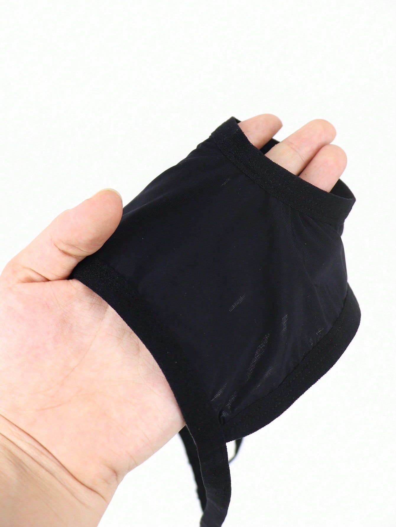 Black men's low-rise thong underwear made from breathable knitted fabric with medium stretch and a plain opaque design.