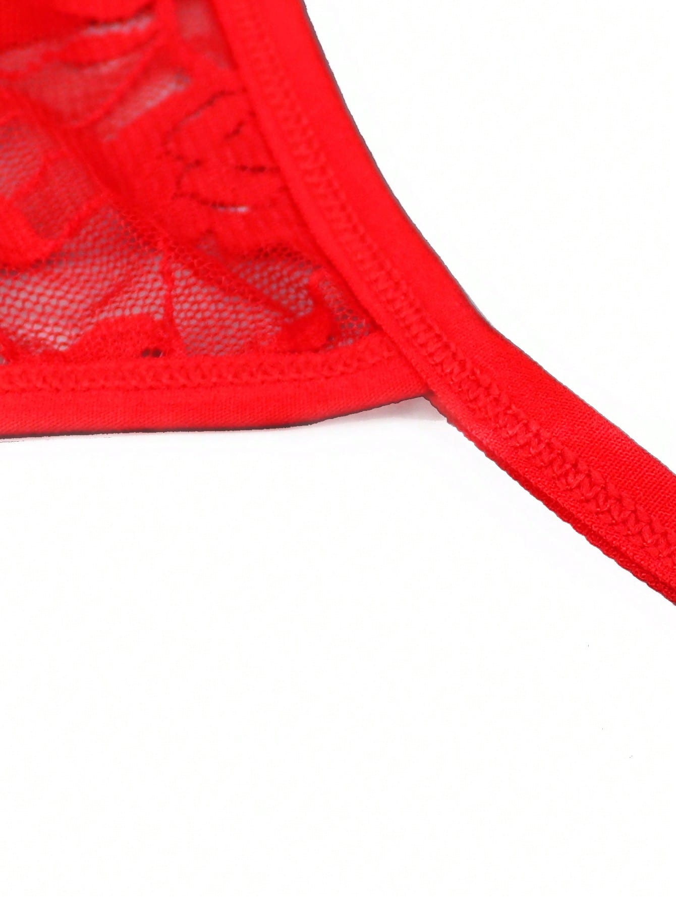 Red men's low rise thong underwear with contrast lace trim, letter pattern, and medium-stretch knitted fabric in 97% polyamide and 3% elastane.