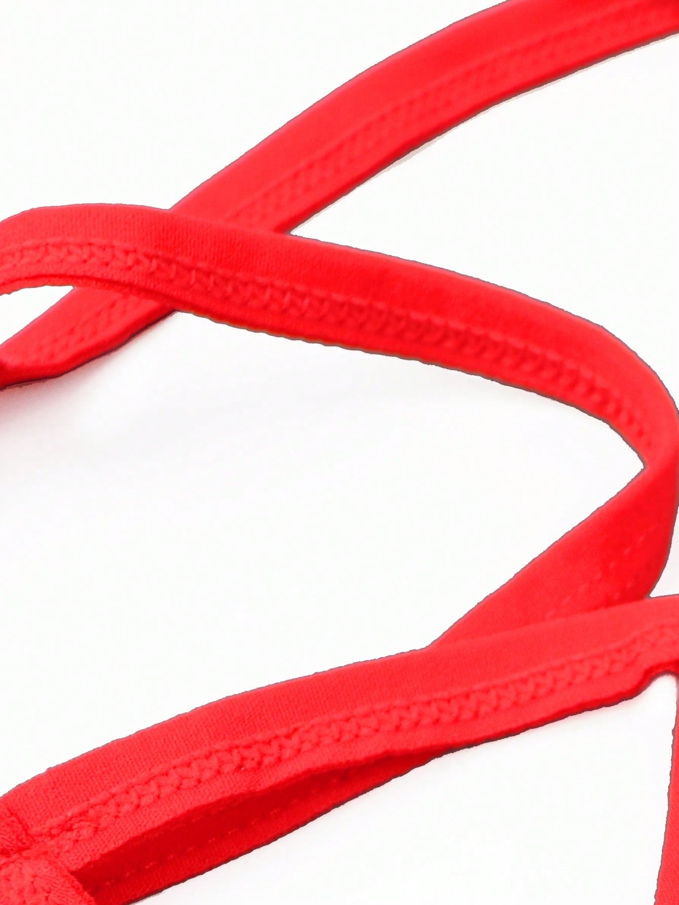 Red men's low rise thong underwear with contrast lace trim, letter pattern, and medium-stretch knitted fabric in 97% polyamide and 3% elastane.