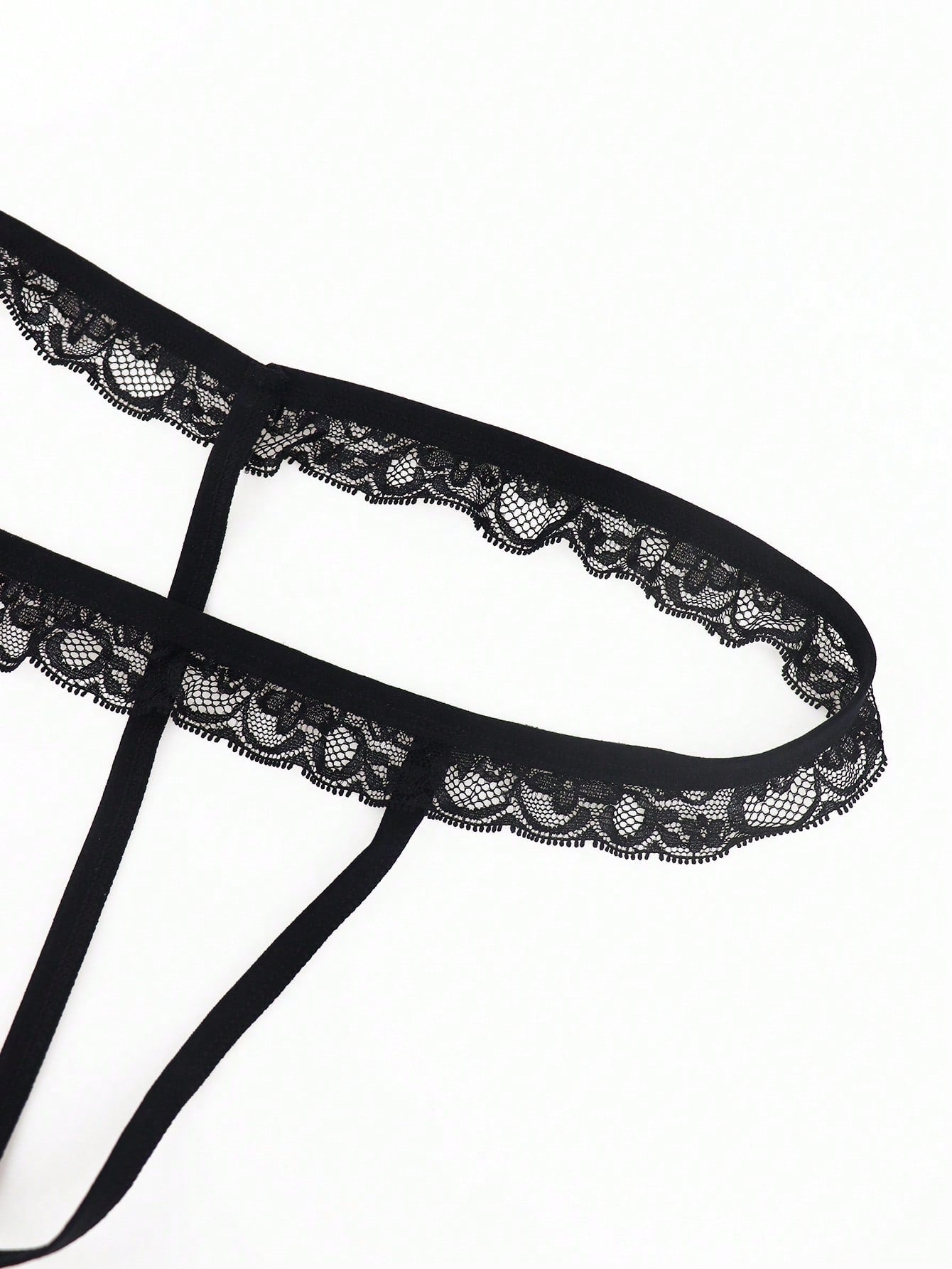 Black men's low rise thong underwear in knitted fabric with lace styling, letter pattern, medium stretch, and a non-sheer finish.